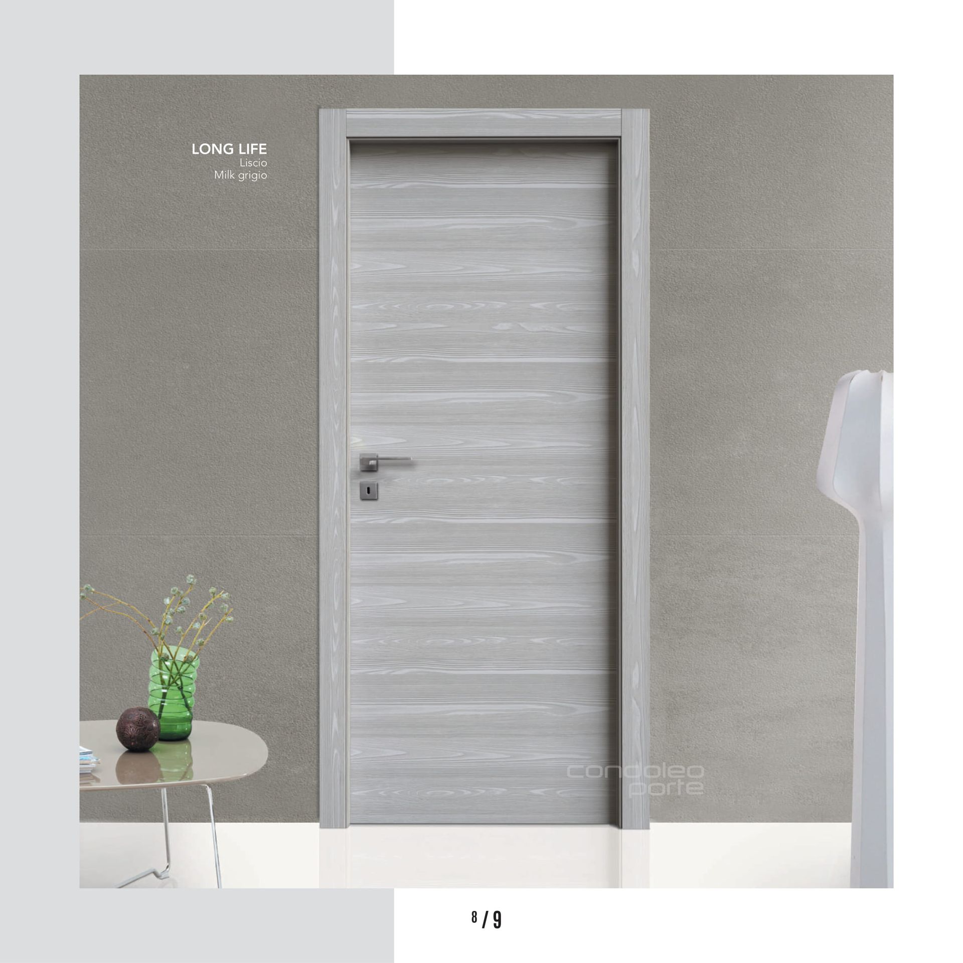 Porta grigia in una stanza minimalista con un tavolino e una pianta accanto.
