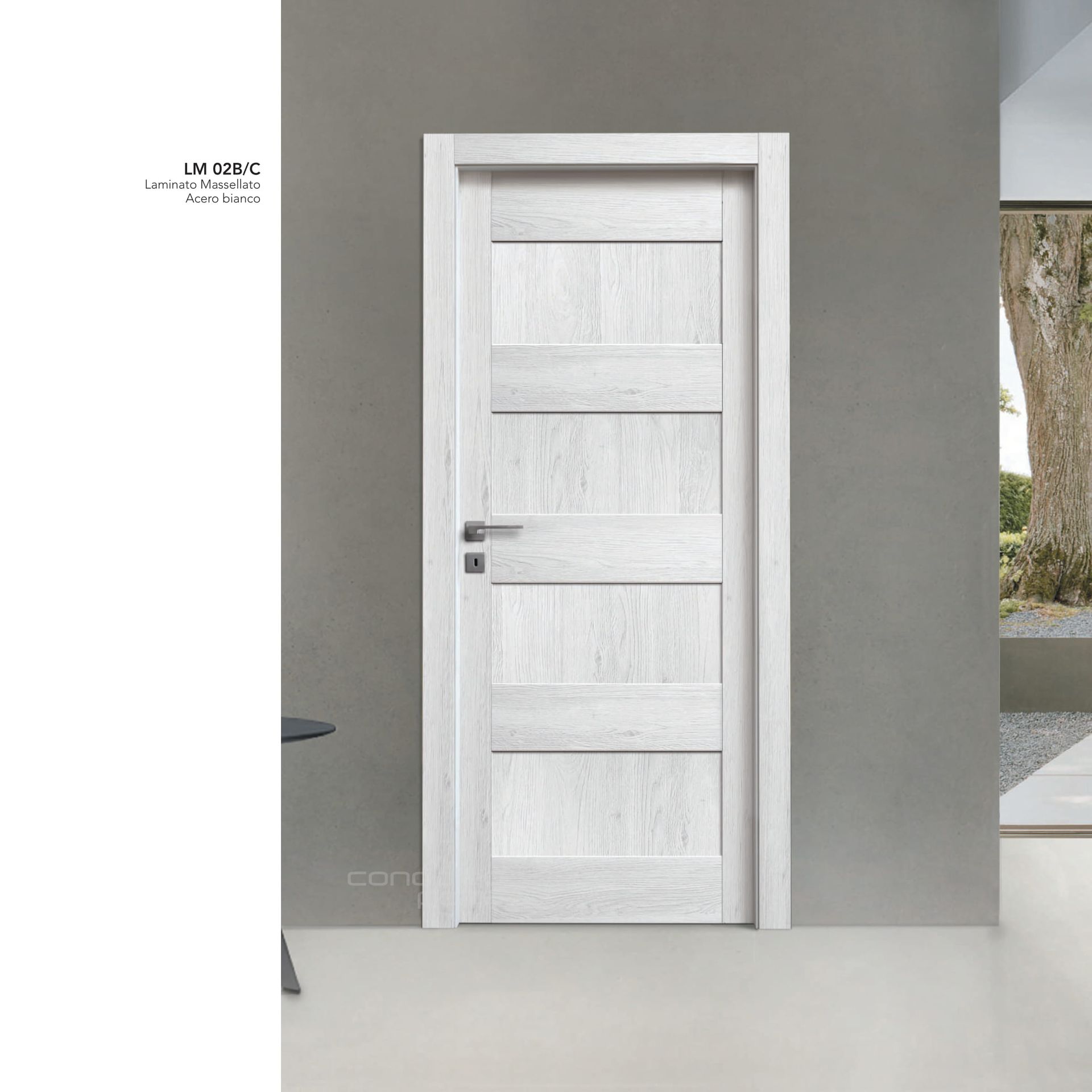 Porta interna con pannelli in legno bianco in un corridoio grigio, con maniglia argentata.