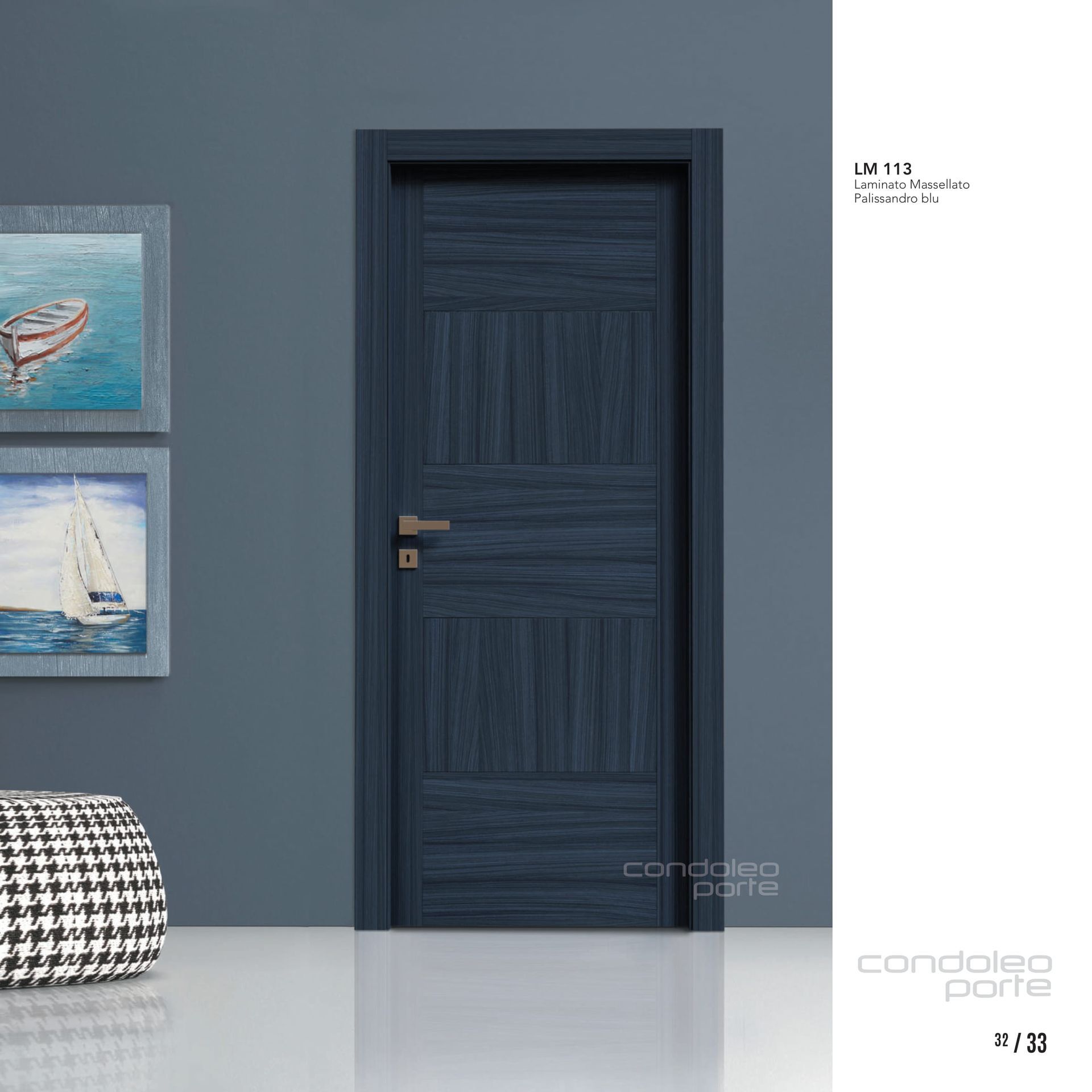 Porta interna blu scuro su una parete grigio-blu, accanto a un quadro incorniciato e a un pouf a scacchi.