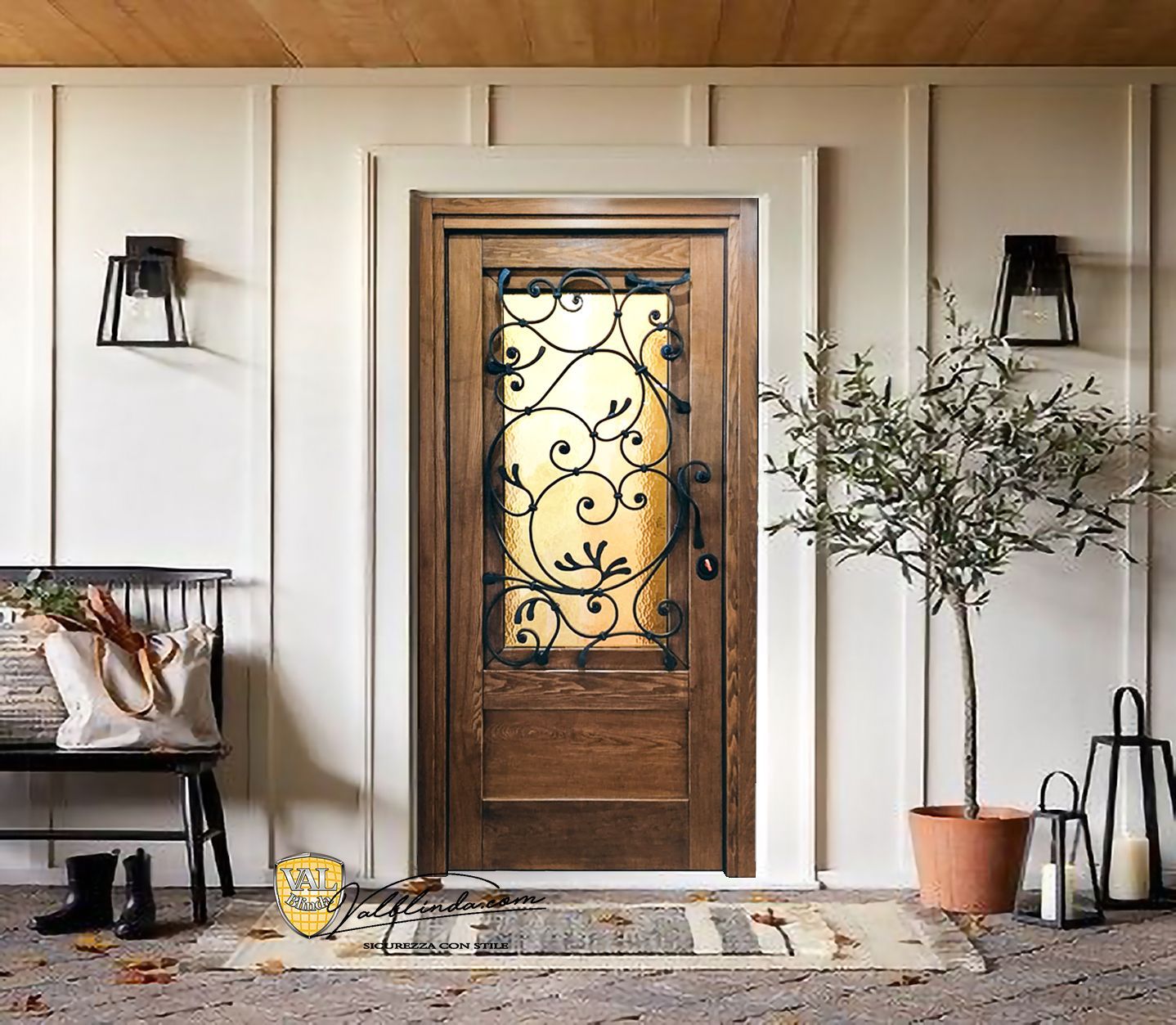 Porta d'ingresso in legno con pannelli di vetro decorati, fiancheggiata da lanterne, ulivo in vaso e panchina su un portico.