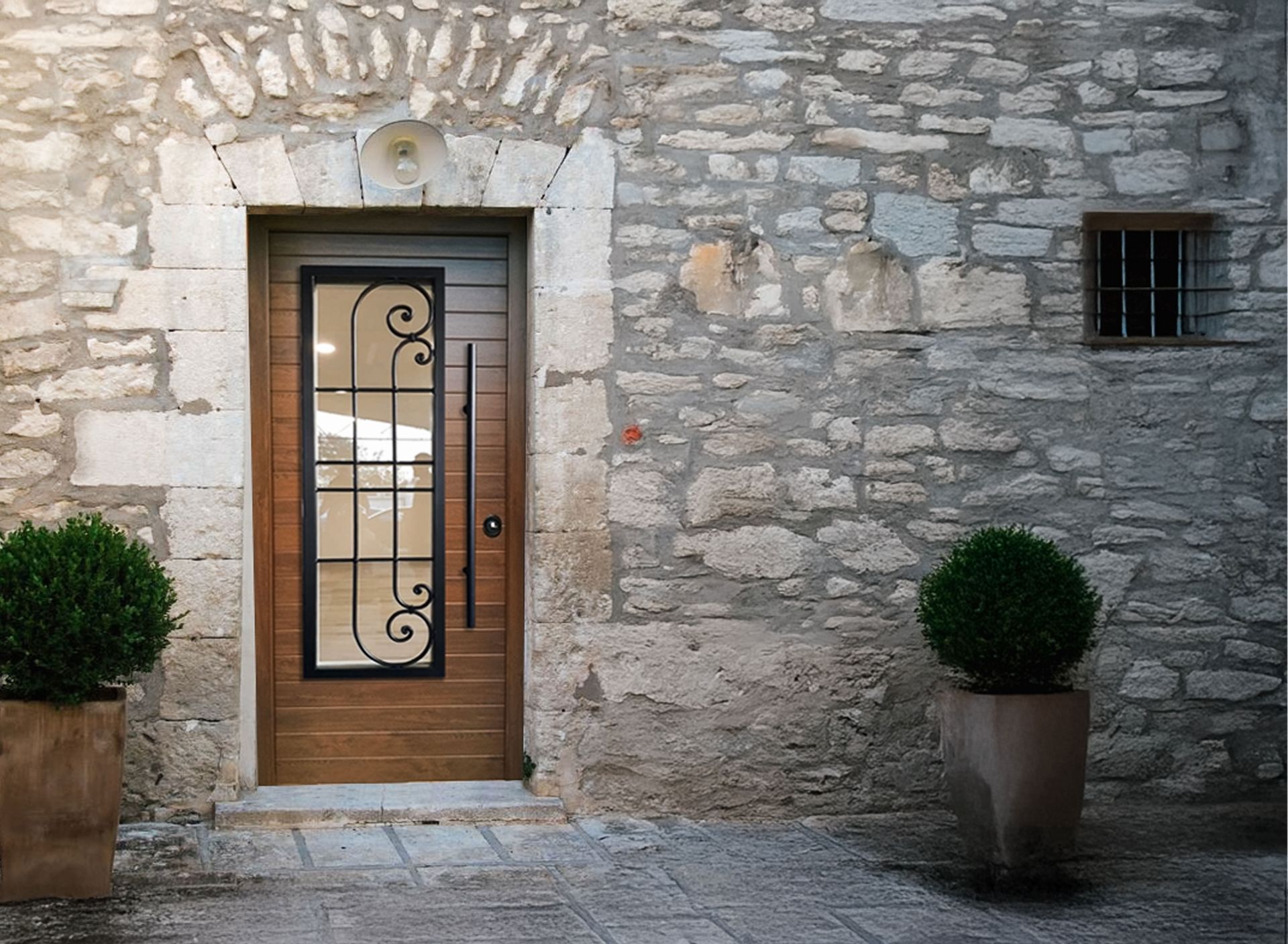 Ingresso principale con porta in legno, pannello decorativo in vetro e piante in vaso su entrambi i lati.