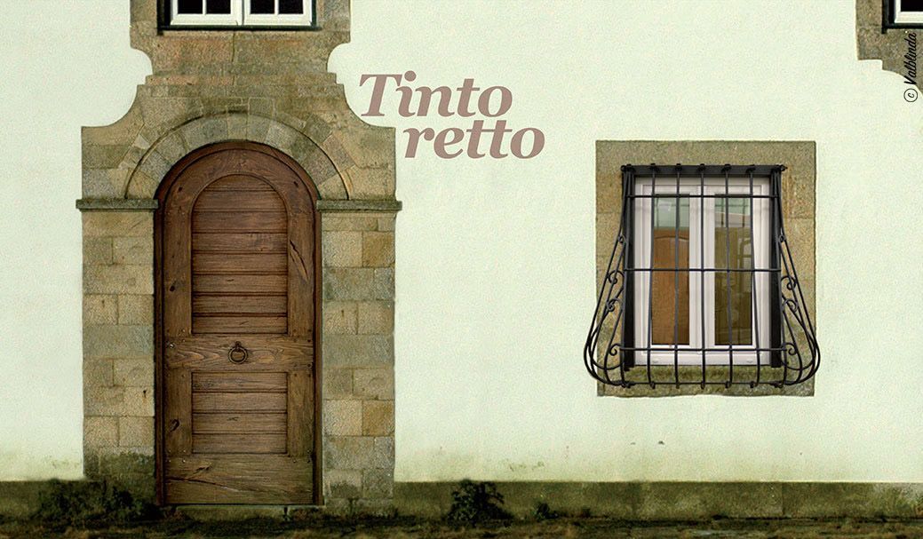 Facciata dell'edificio in pietra con porta ad arco in legno, finestra con sbarre e insegna