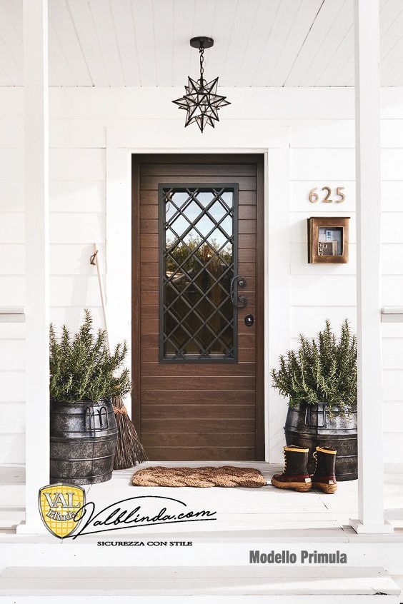 Veranda anteriore con porta in legno scuro, rivestimento esterno bianco, piante in vaso e numero civico 625.