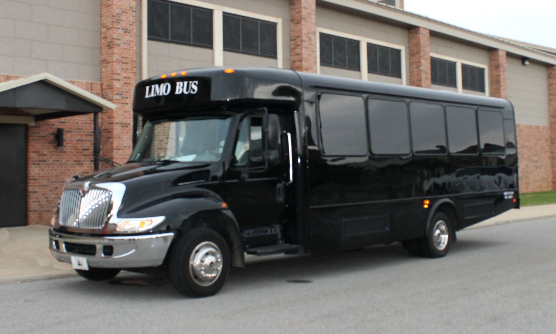 Black limo bus parked outside a building