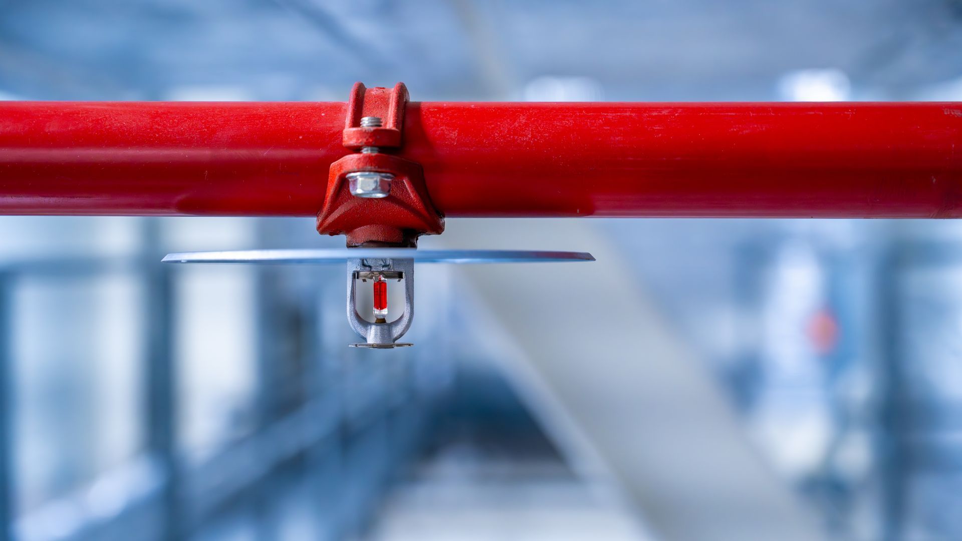 A fire sprinkler on a red fire pipe, showcasing a fire security system. A fire sprinkler on a red fire pipe, showcasing a fire security system.