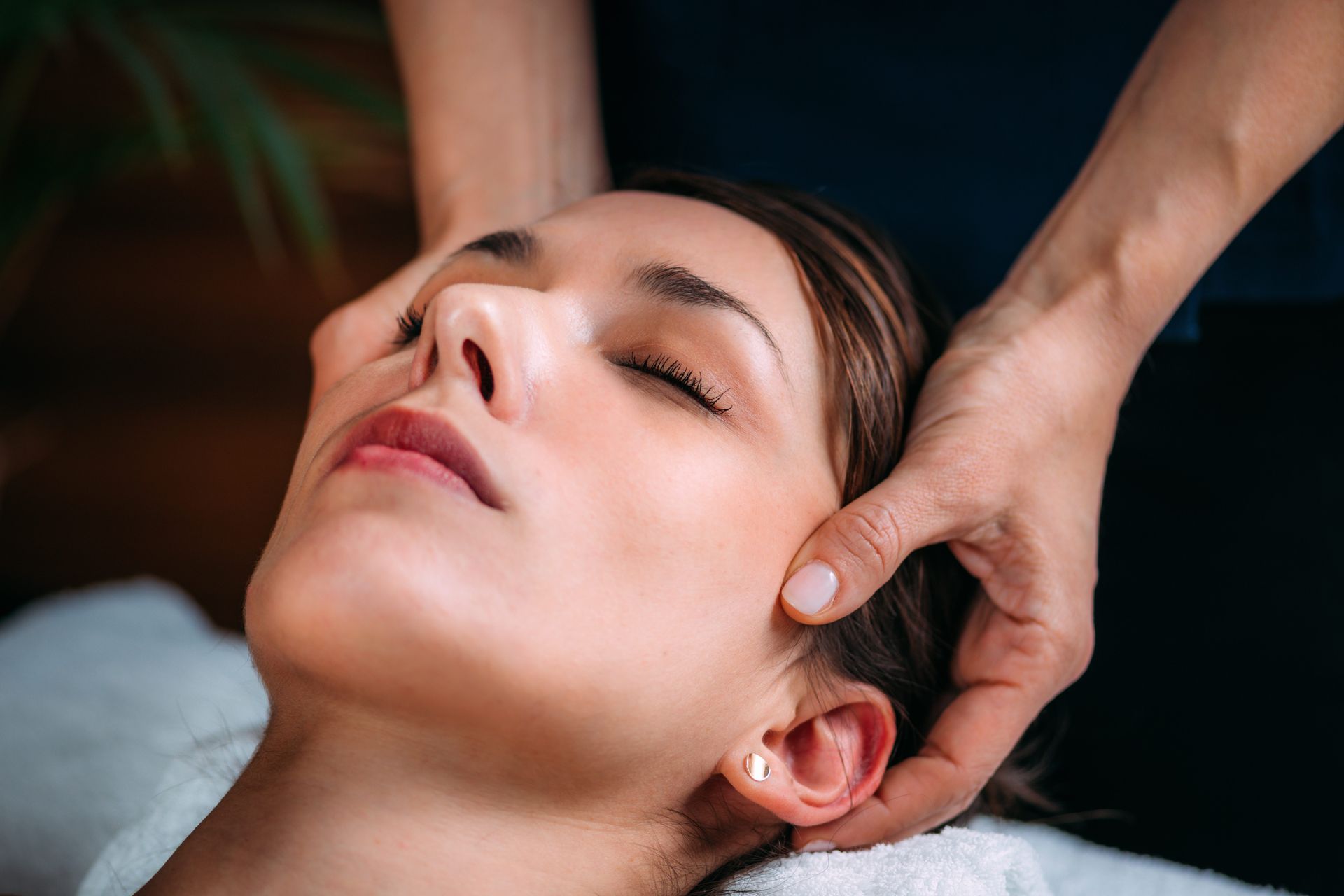 a woman is getting a head massage at a spa