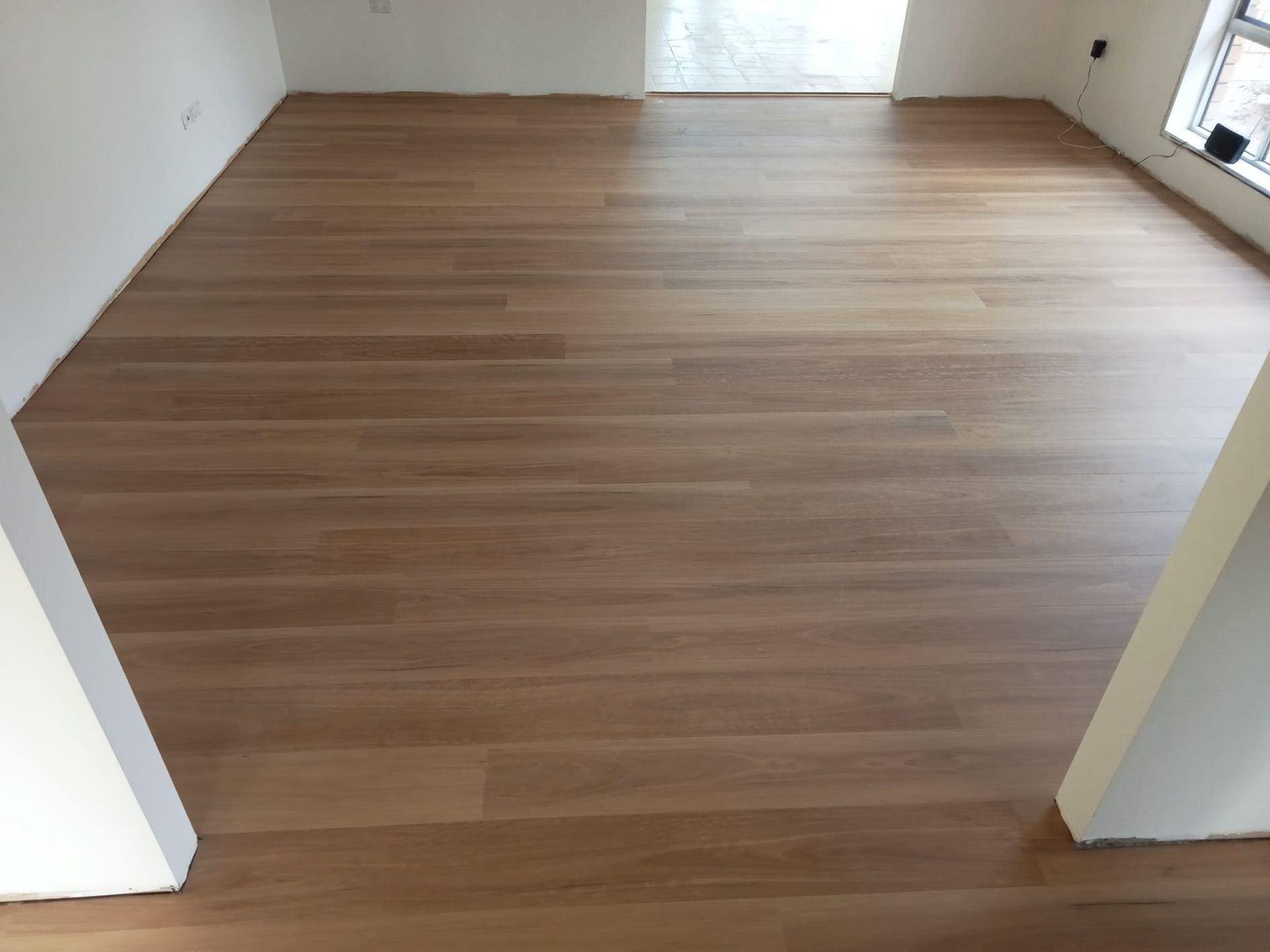 A Room With a Wooden Floor and White Walls — BLB Flooring Solutions in Central Coast, NSW