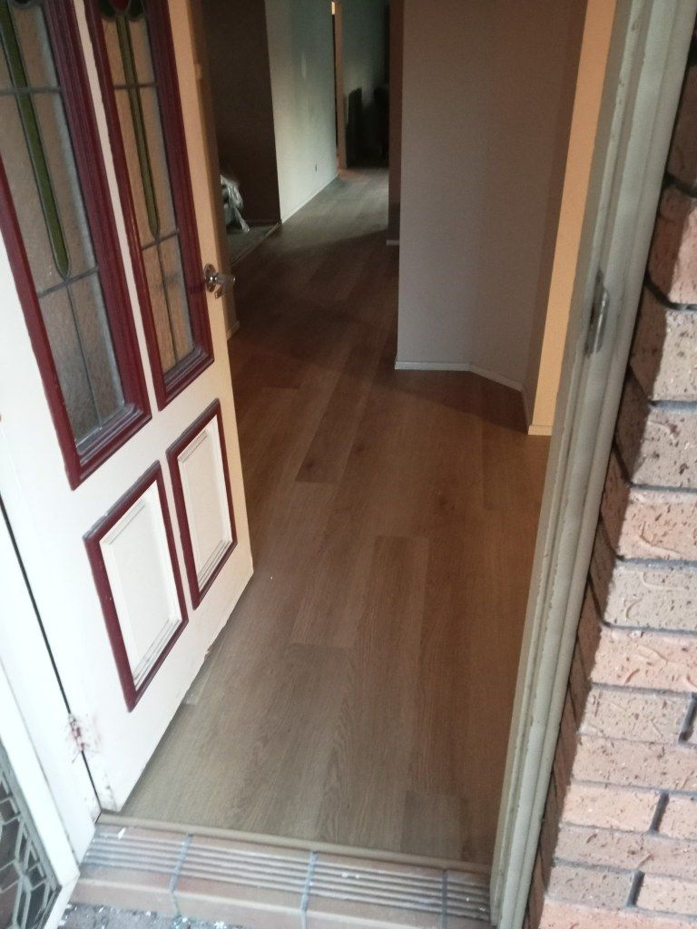 A Door is Open to a Hallway With a Wooden Floor — BLB Flooring Solutions in Central Coast, NSW