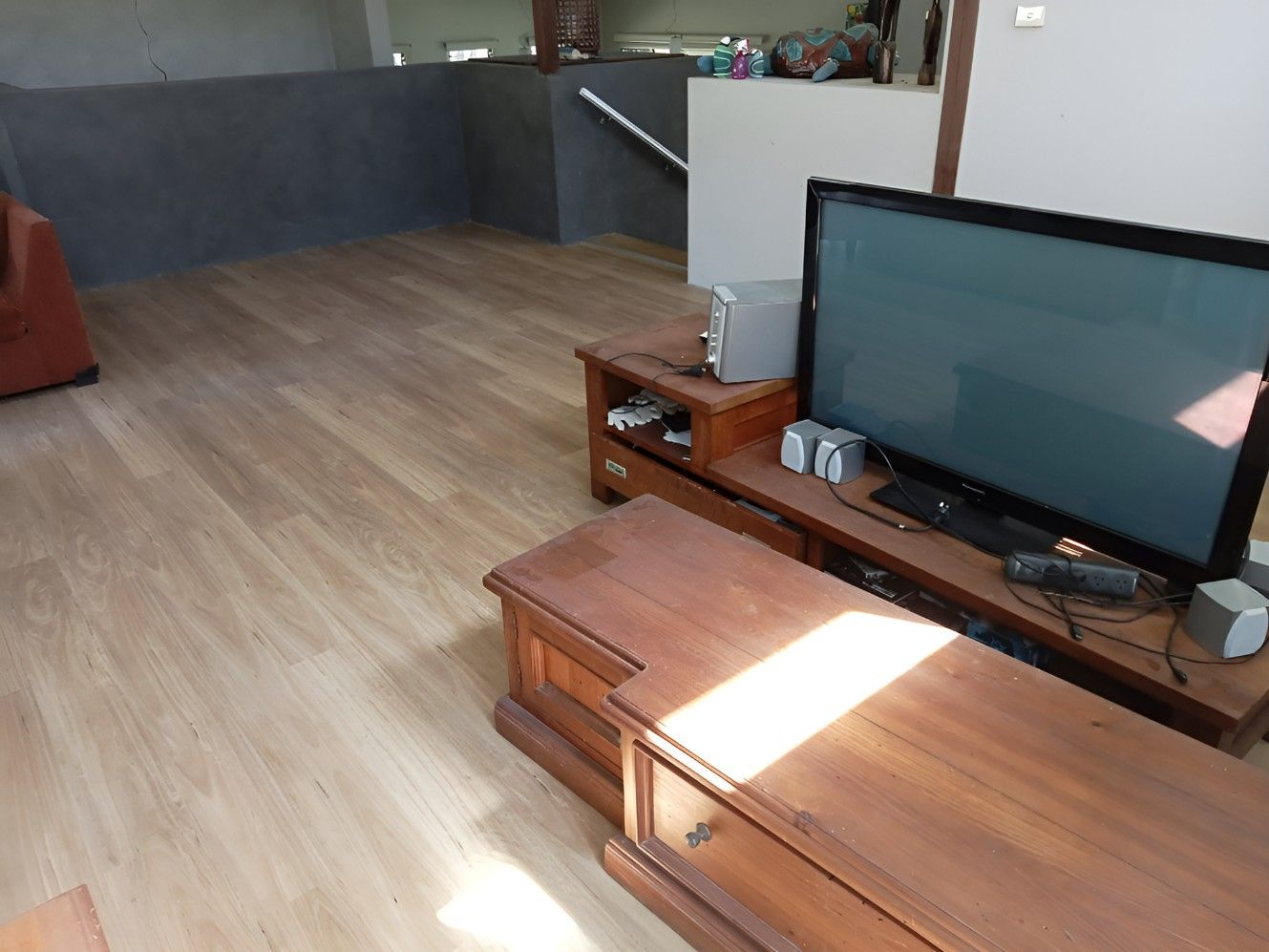 A Living Room With a Flat Screen Tv on a Wooden Entertainment Center — BLB Flooring Solutions in Central Coast, NSW