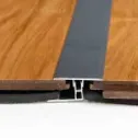 A Metal Transition Strip Joins Two Sections of Wooden Flooring — BLB Flooring Solutions in Central Coast, NSW