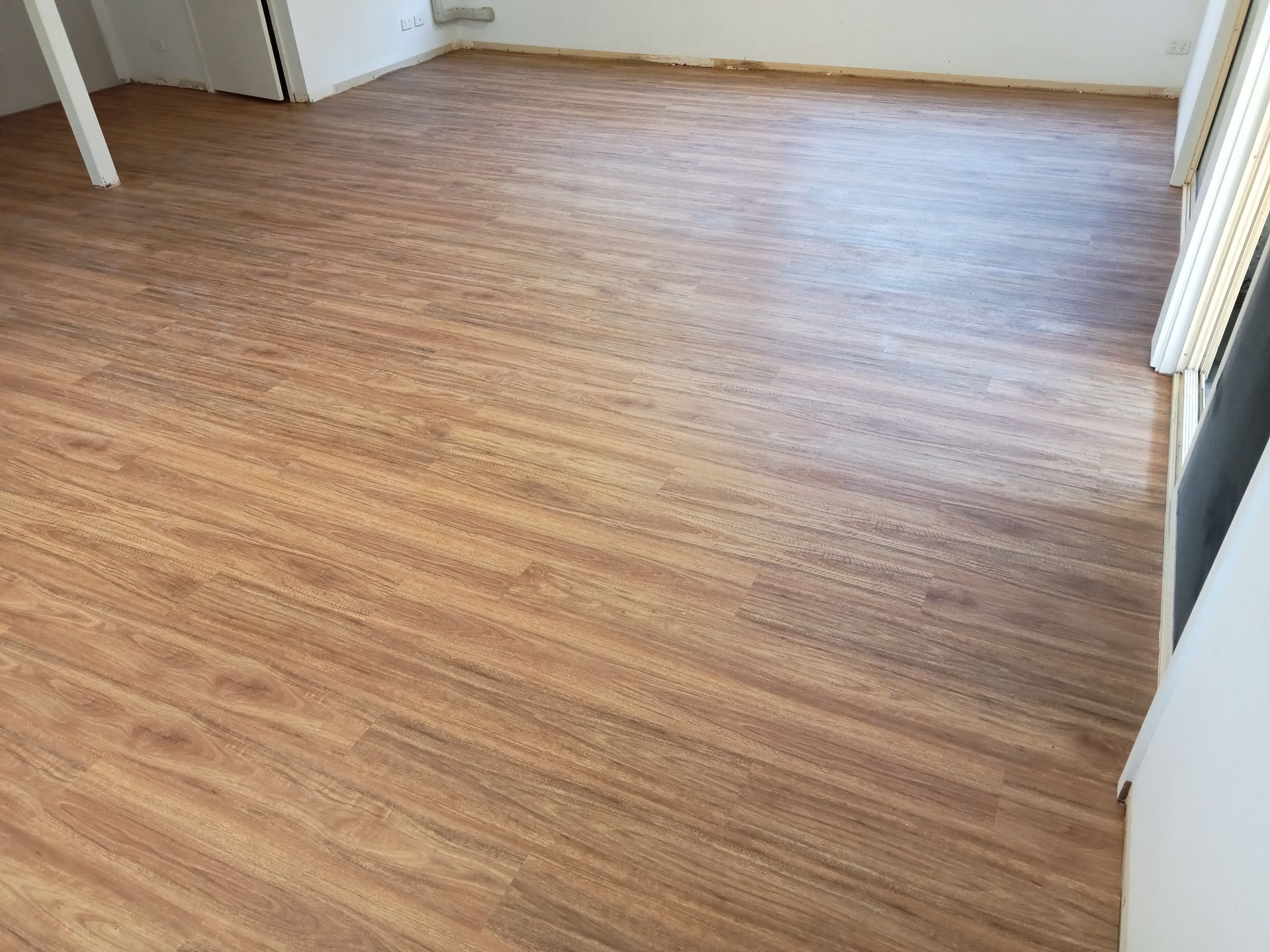 A Living Room With a Wooden Floor and White Walls — BLB Flooring Solutions in Central Coast, NSW
