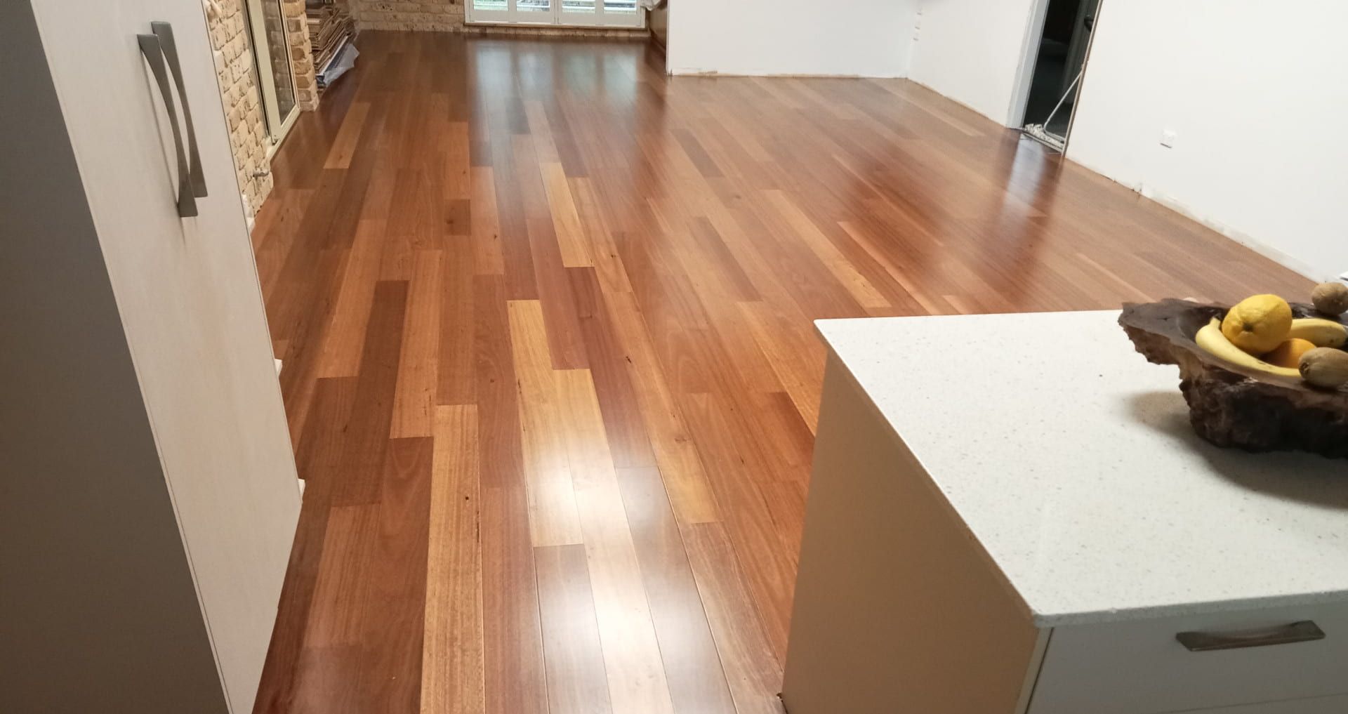 A Wooden Floor in a Living Room With a Bowl of Bananas on It — BLB Flooring Solutions in Central Coast, NSW