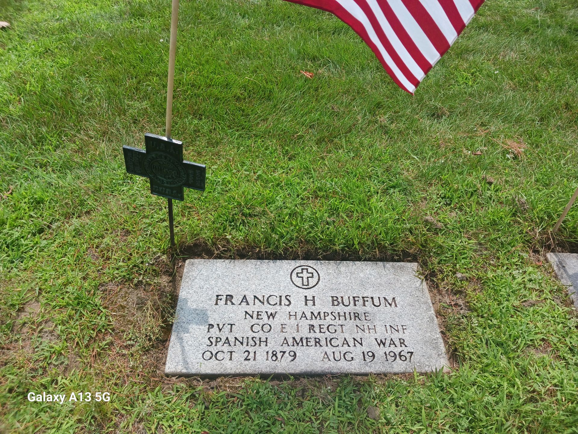 Grave of Francis H. Buffum, a Spanish-American War veteran from New Hampshire, marked with a flag and a cross.