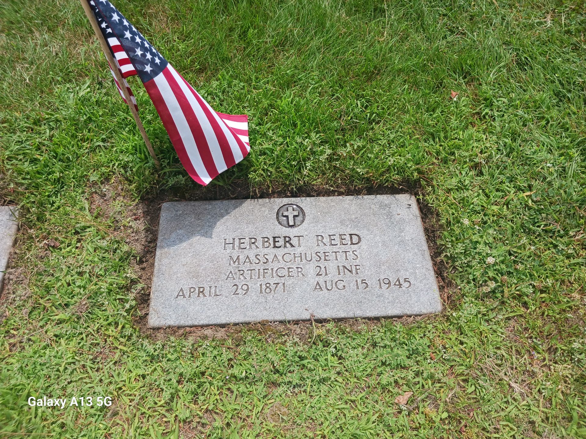 Grave of Herbert Reed, with an American flag. The headstone reads his name, birth/death dates, and other details.