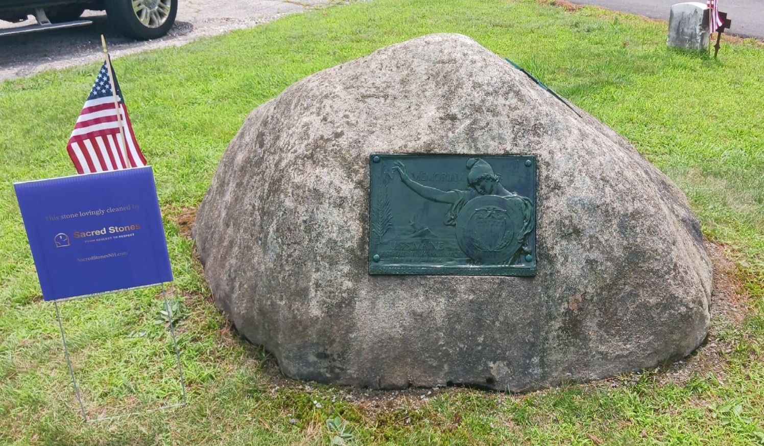 A large boulder with a bronze plaque depicting a warrior. 