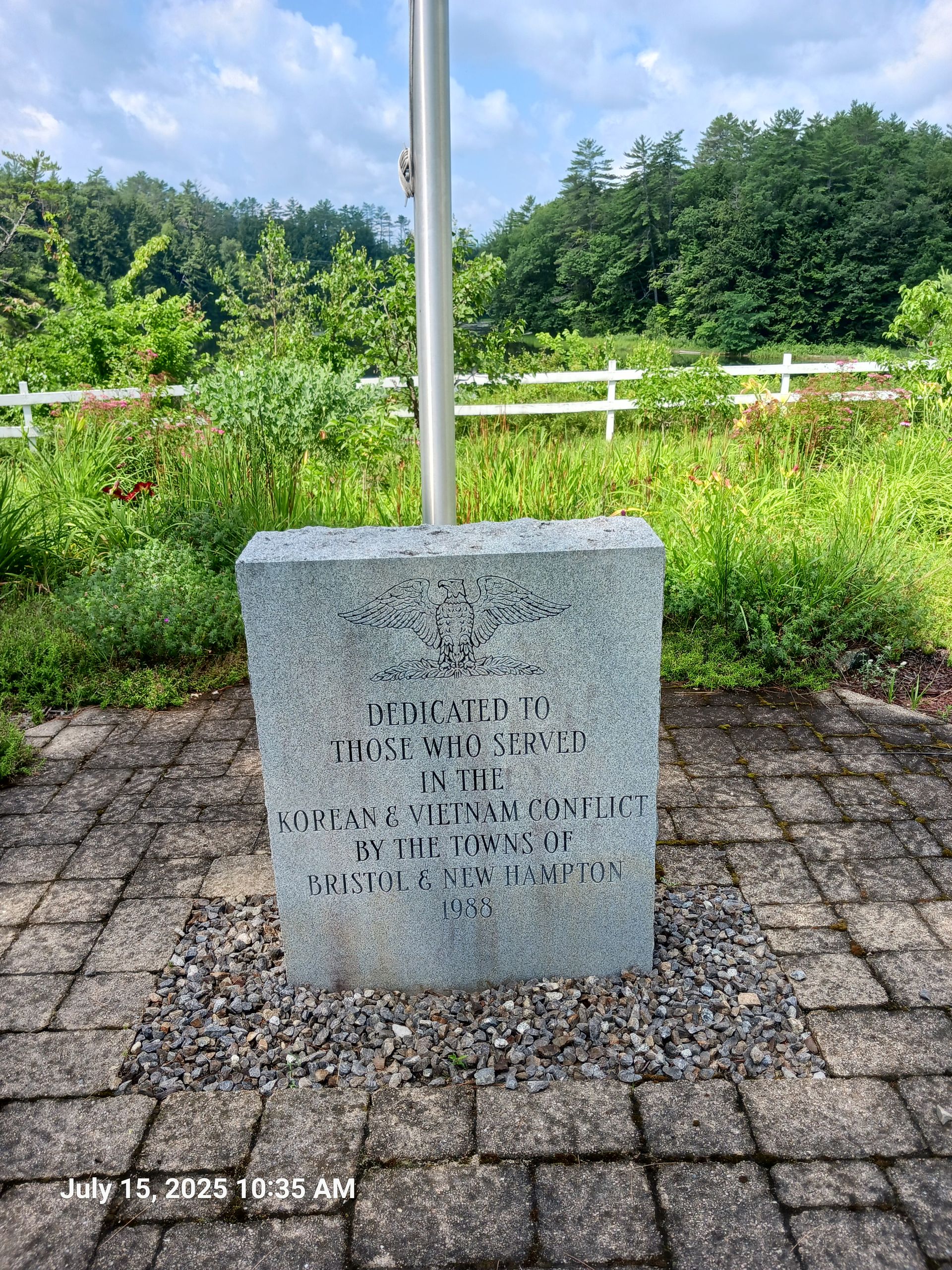 Cleaned war memorial in New Hampton, New Hampshire,  with an eagle carving at the top and text on a stone.