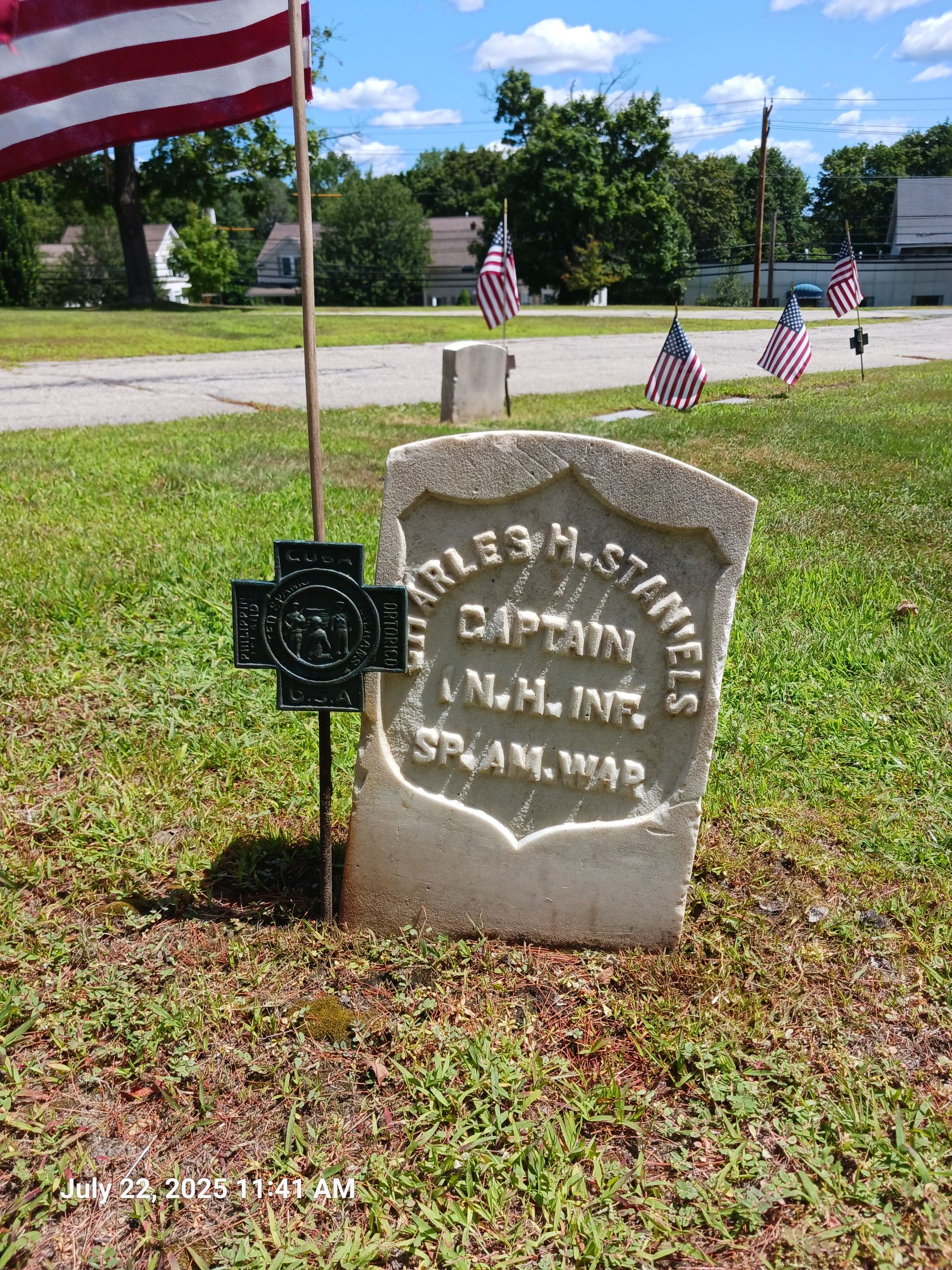 Grave of Charles H. Staniels, Captain in the Spanish-American War, with American flags and a memorial marker.
