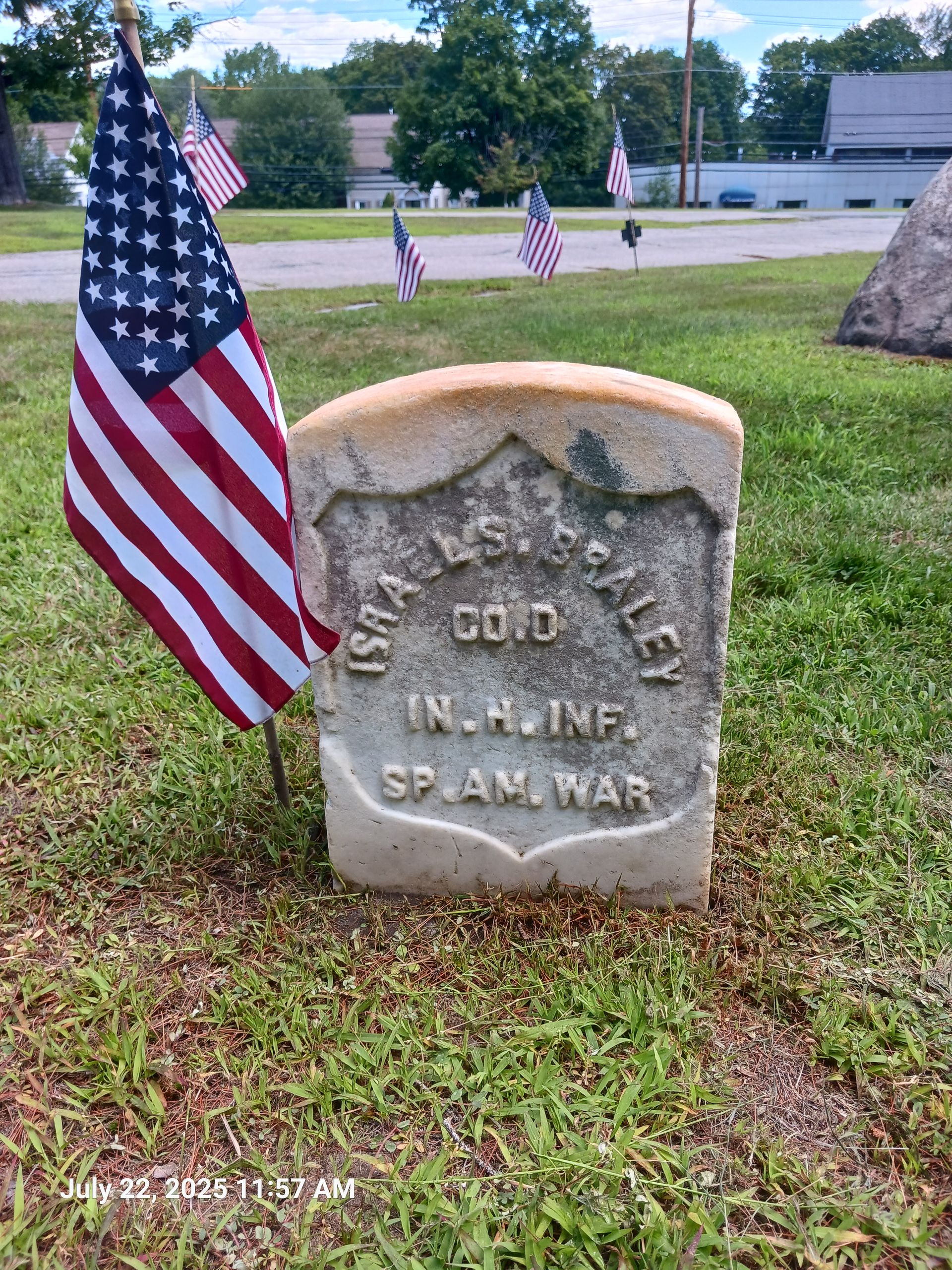Grave marker for Israel S. Braley, a Spanish-American War veteran, with an American flag in a grassy area.