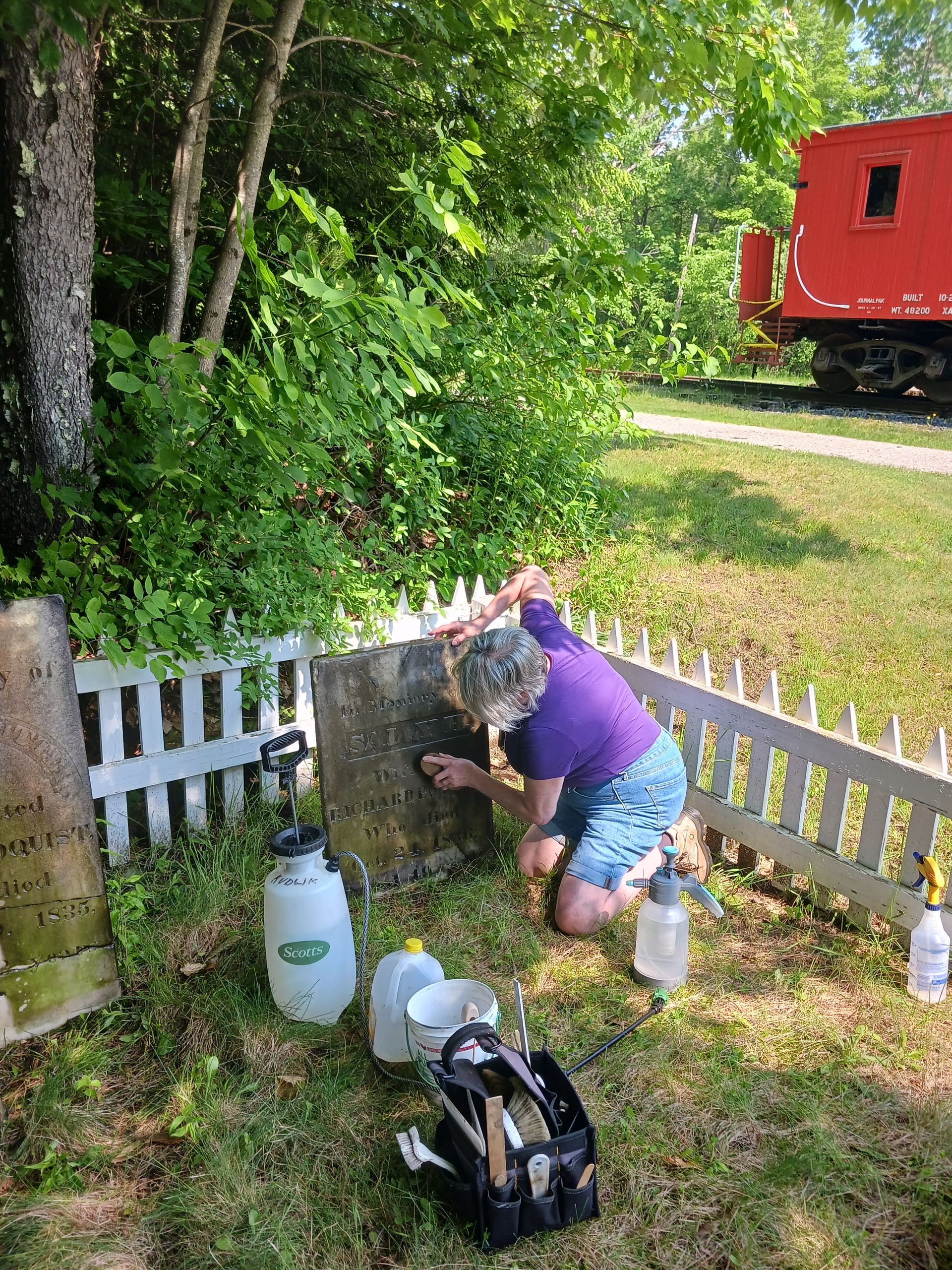 woman cleaning gravestone