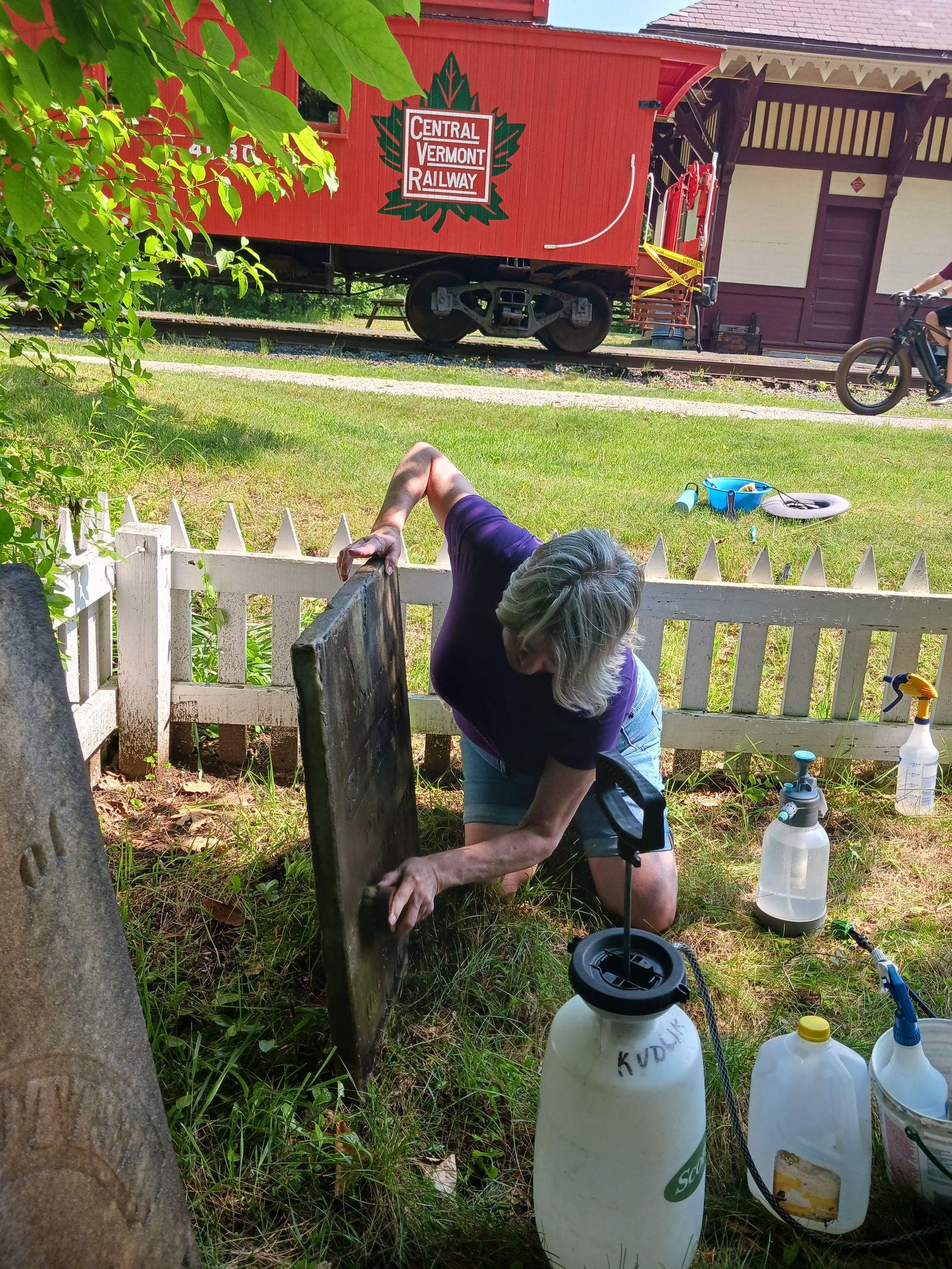 woman cleaning gravestone