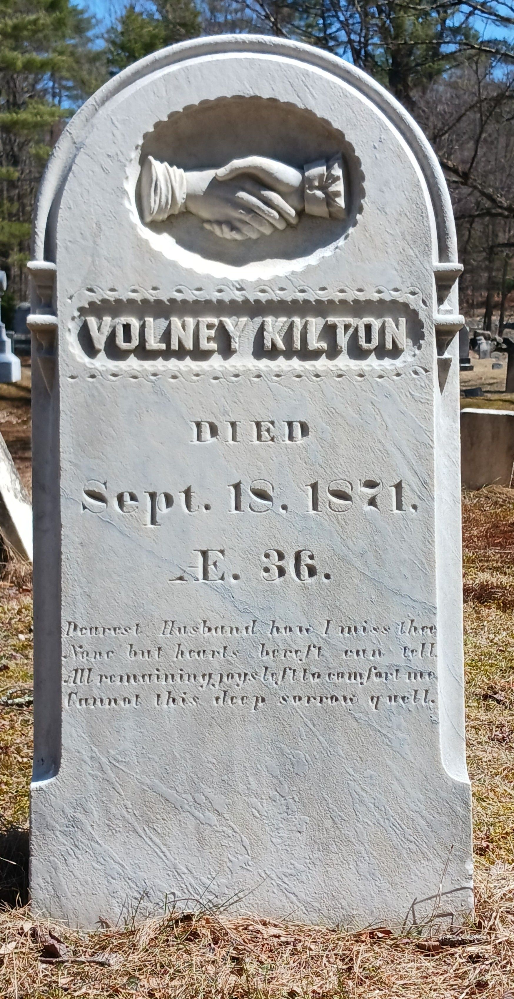 Gravestone of Volney Kilton, who died September 18, 1871, with a carved handshake symbol at the top.