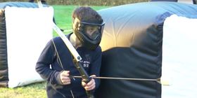 Image of a young archer in protective gear preparing for an archery tag competition. 