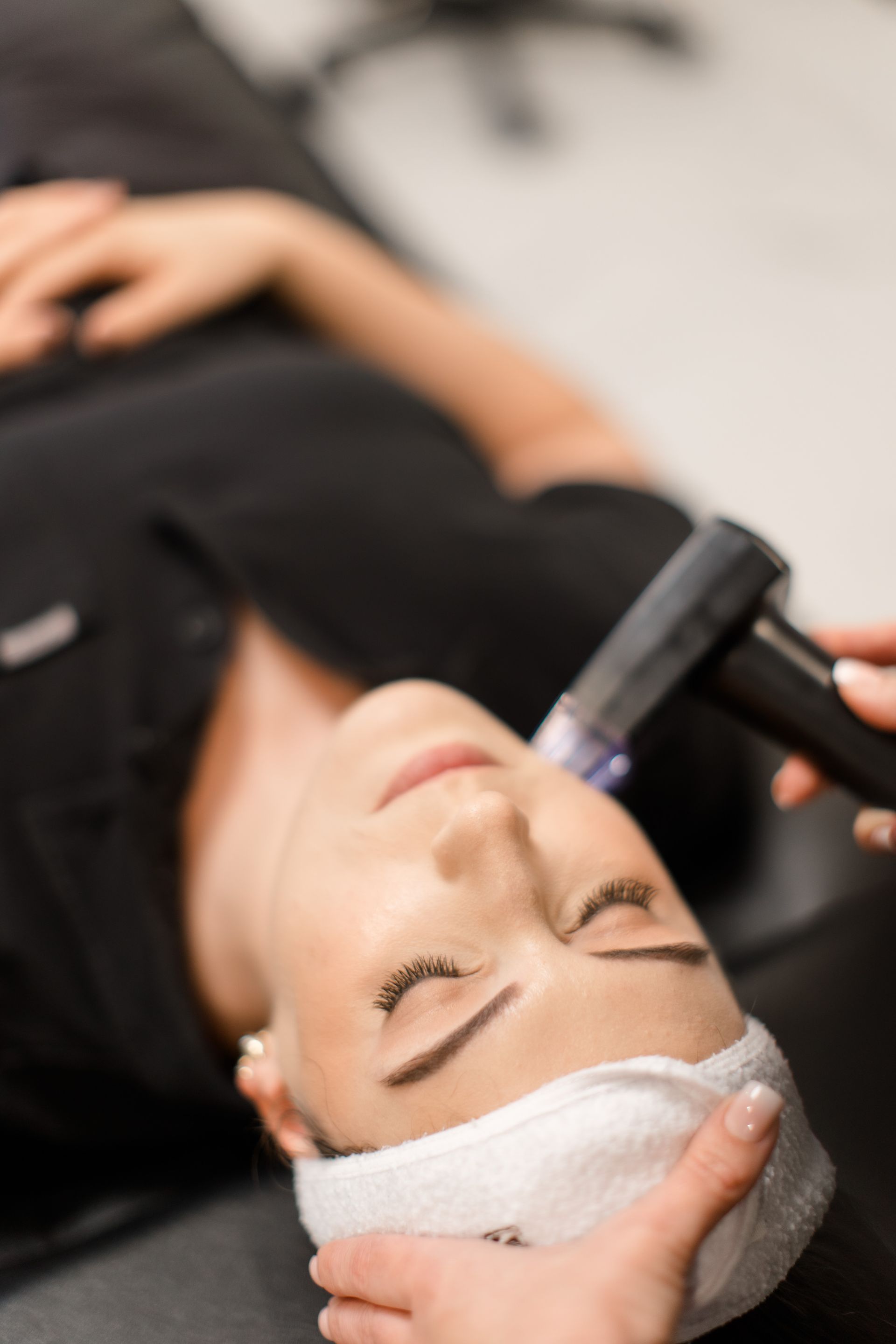 A woman with a mask on her face is getting a facial treatment.