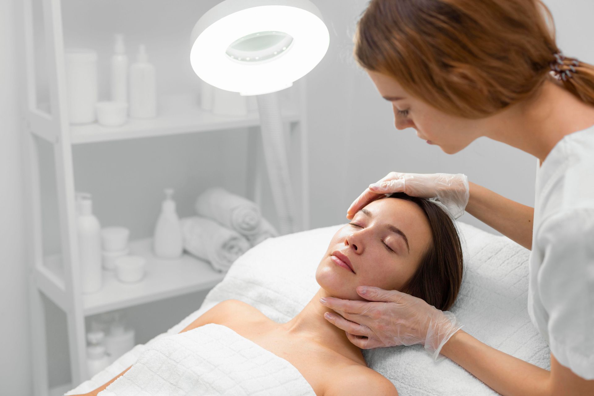 A woman is getting a facial treatment at a beauty salon.