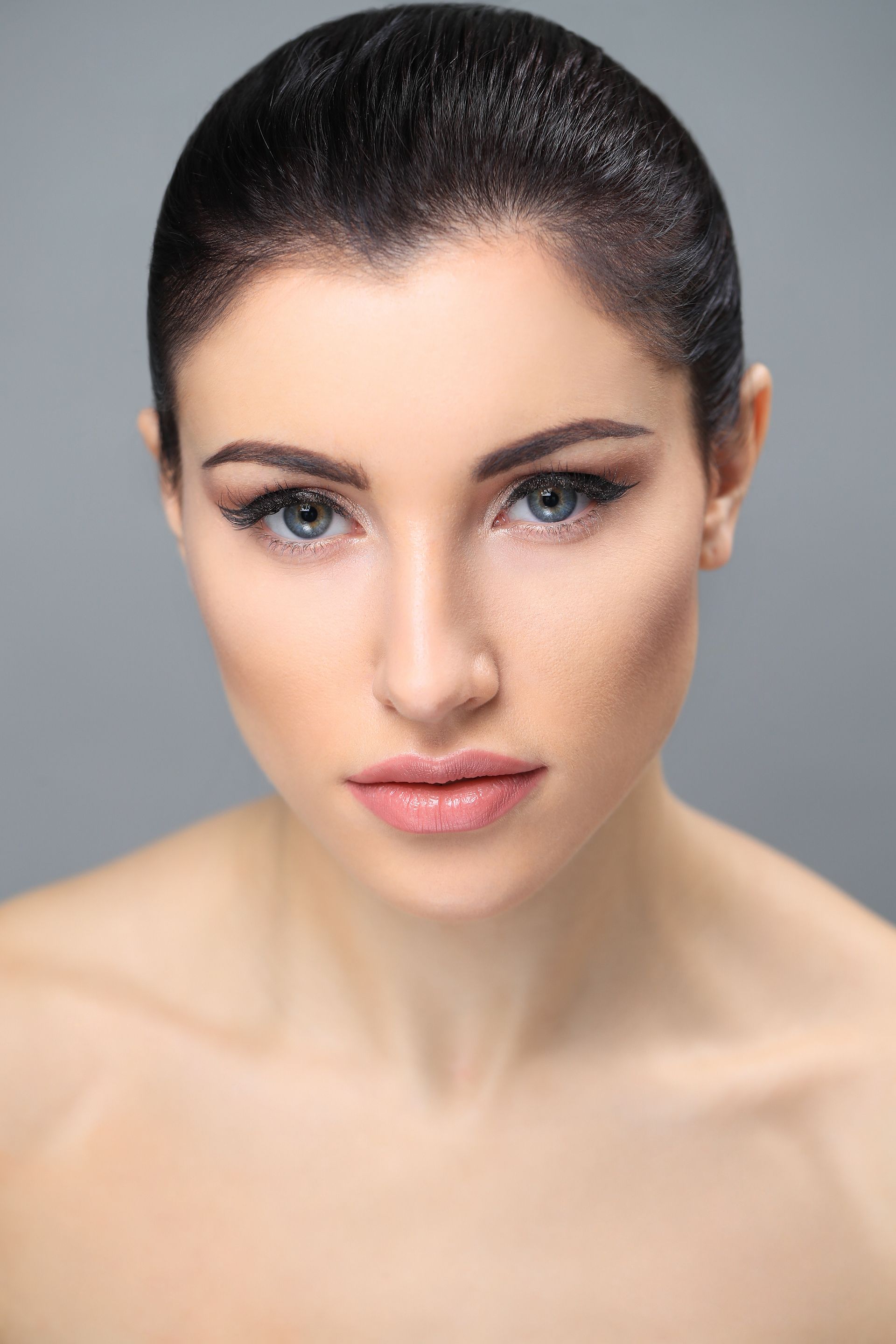 A close up of a woman 's face with a shaved head.