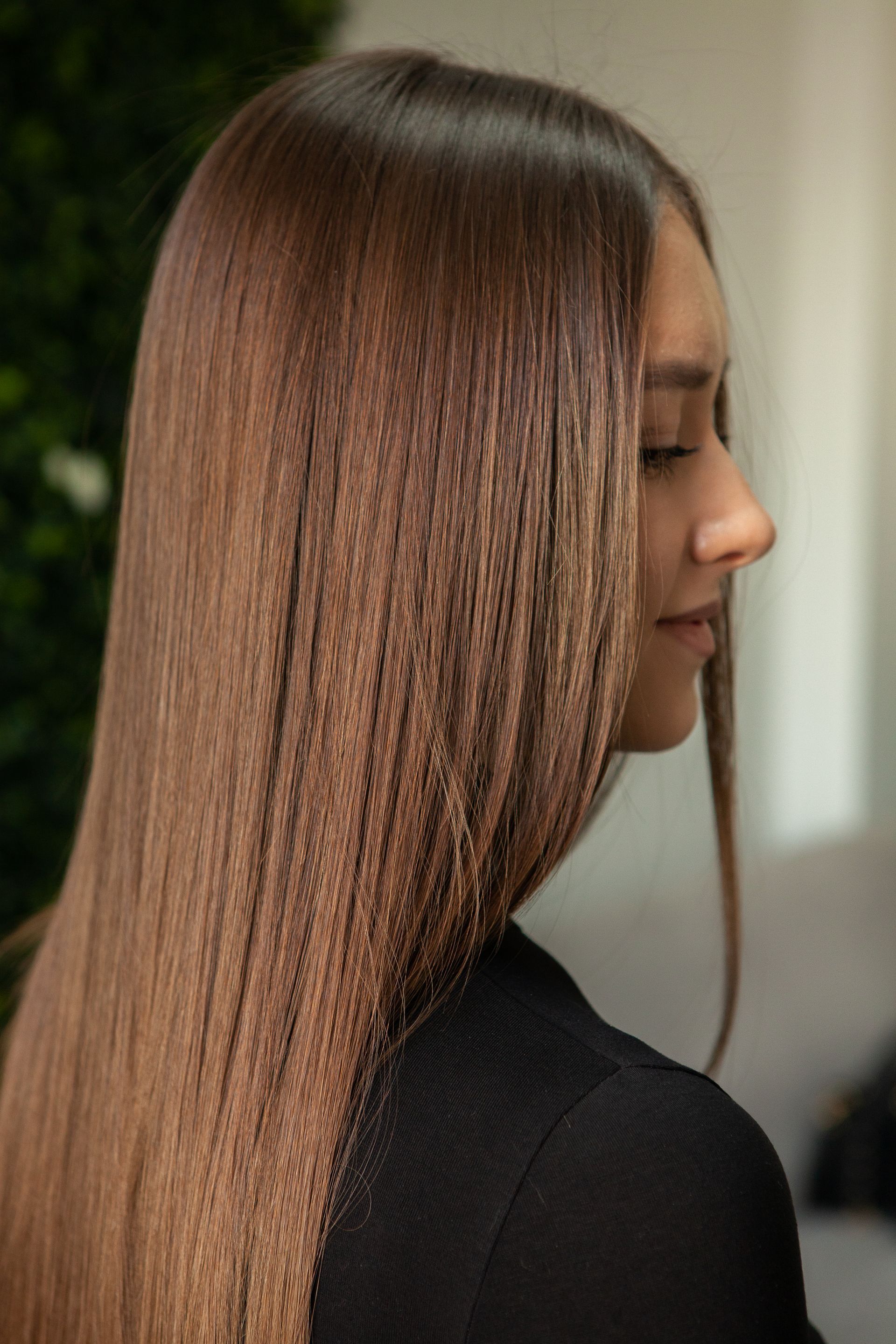 A woman with long brown hair is wearing a black shirt.