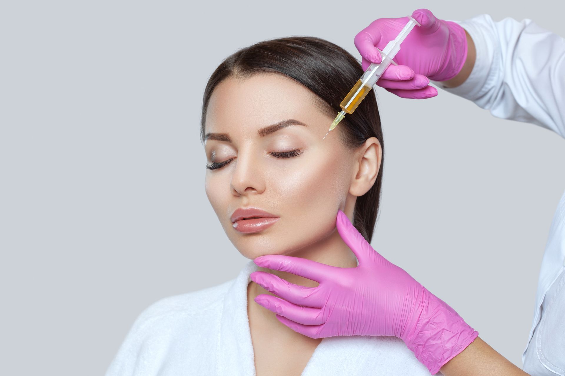 A woman is getting a botox injection in her face.