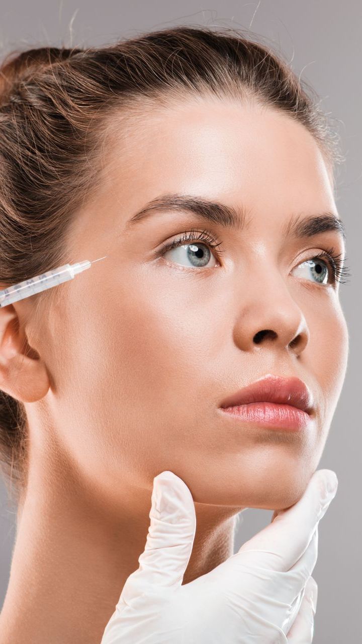 A woman is getting a botox injection in her eye.