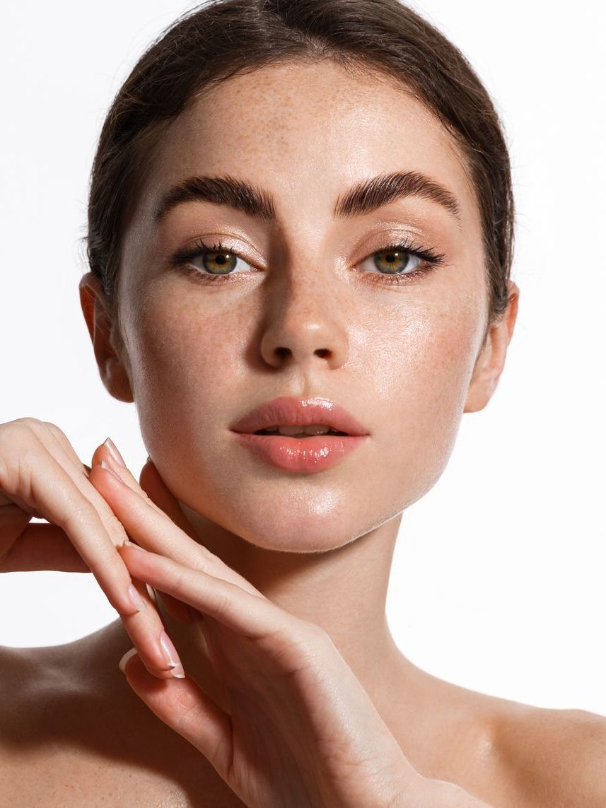 A close up of a woman 's face with her hands on it.