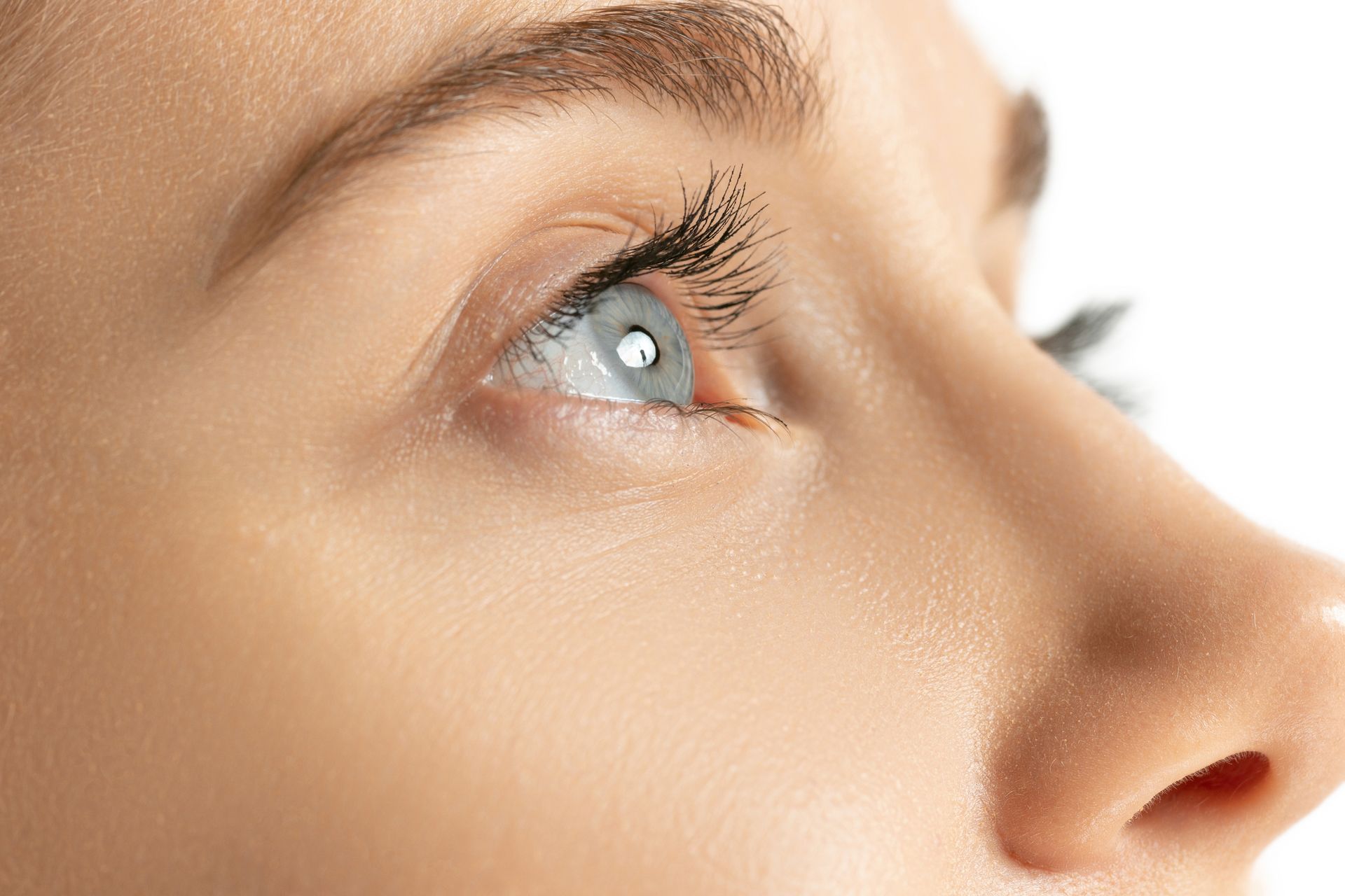 A close up of a woman 's face with a blue eye.
