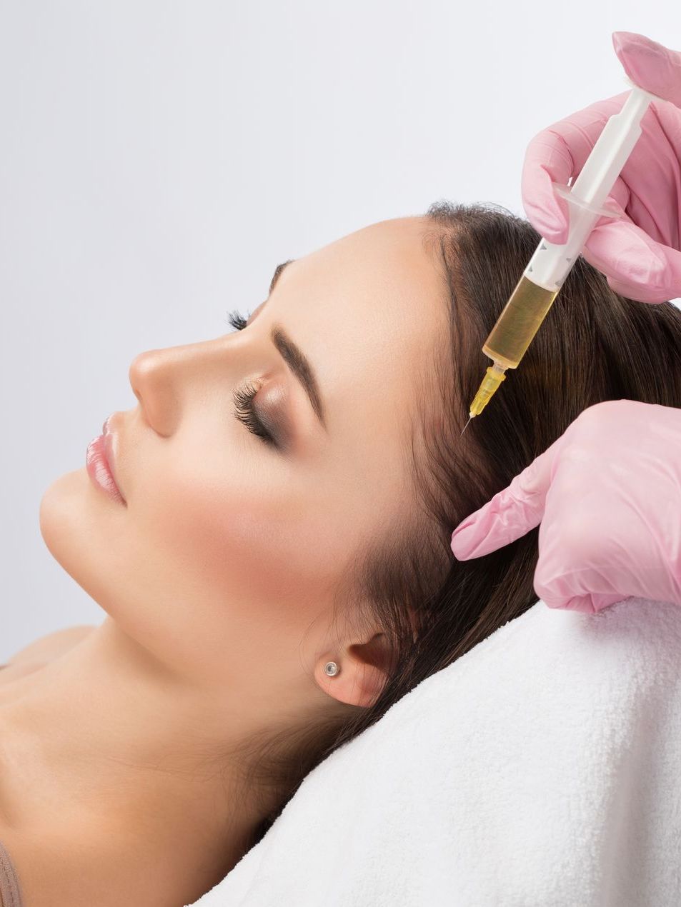 A woman is getting a hair treatment at a beauty salon.