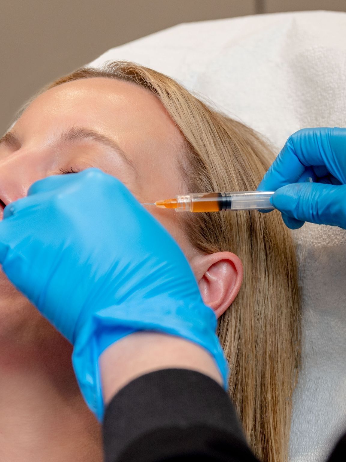 A woman is getting a botox injection in her face.
