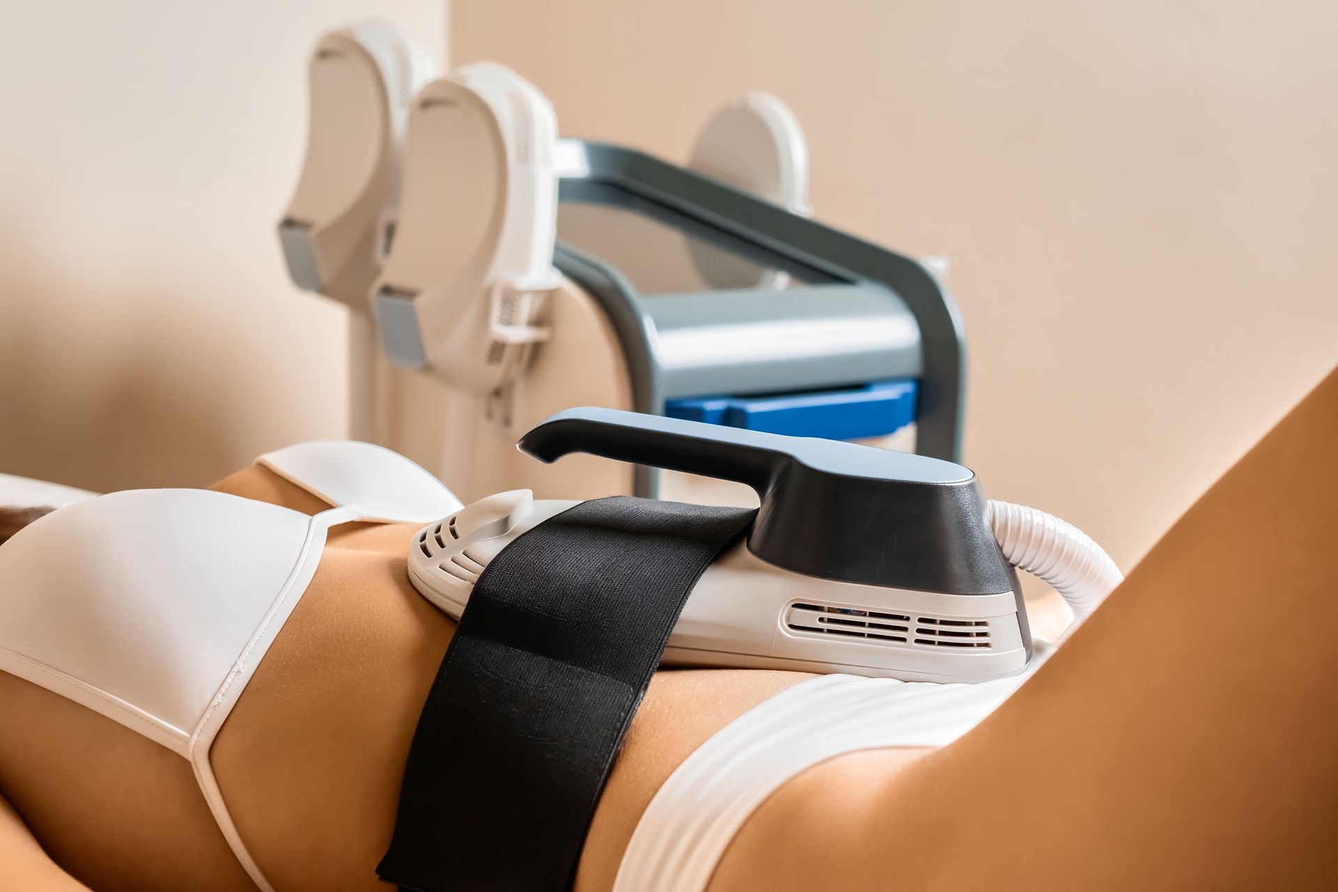 A woman is laying on her stomach with a machine on her stomach.
