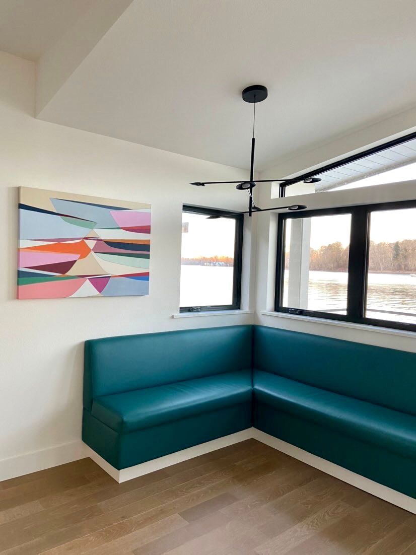 A living room with a couch and a painting on the wall.