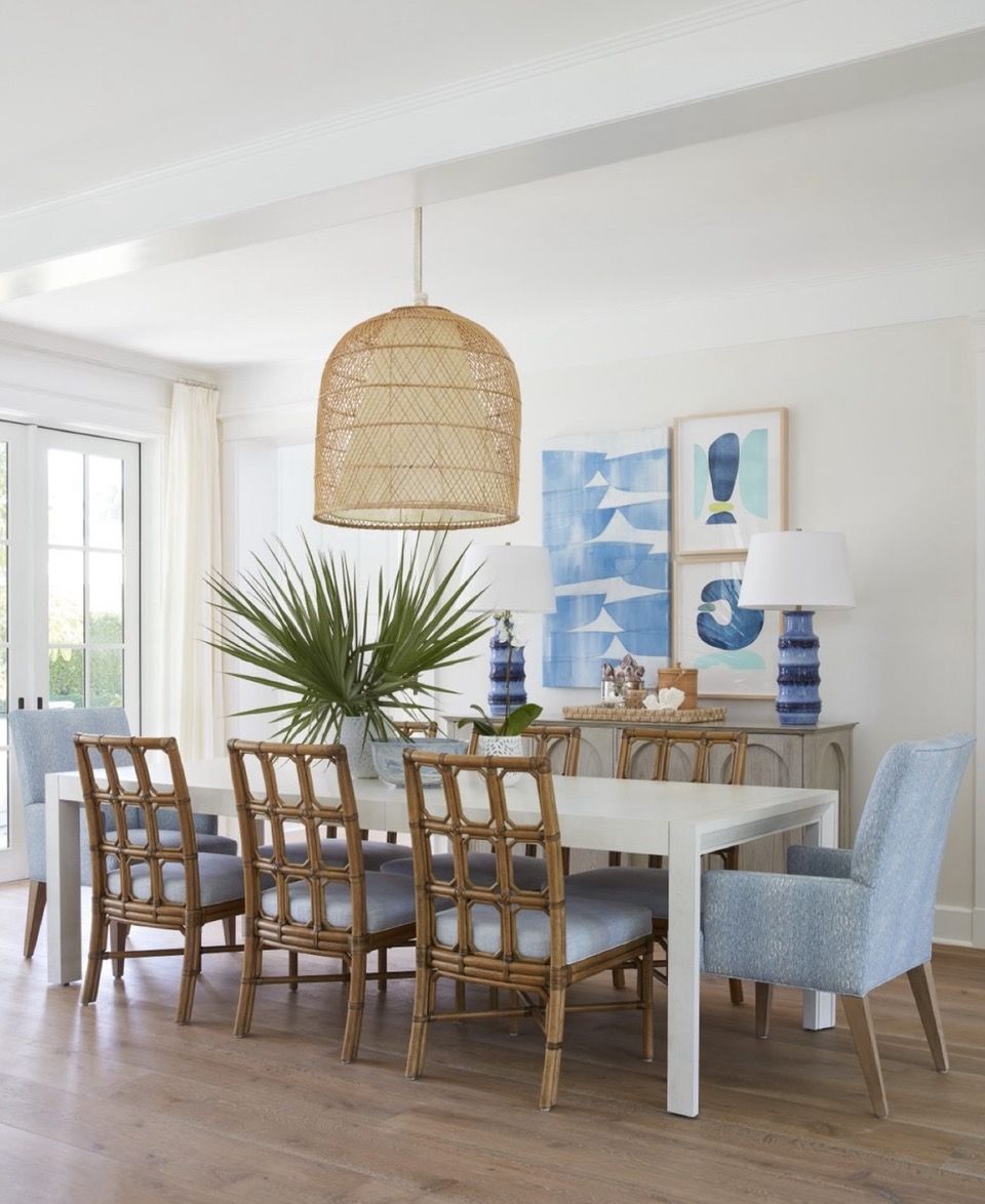 A dining room with wicker chairs and a white table