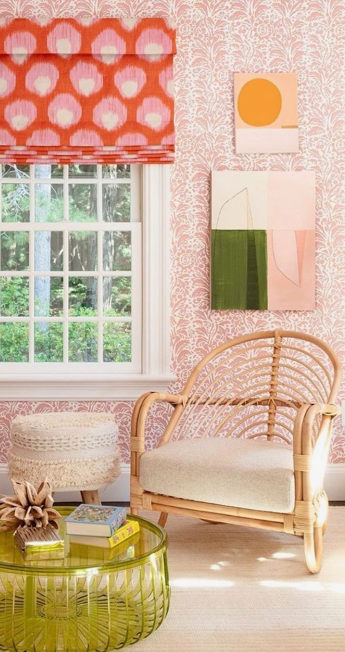 A living room with a wicker chair , coffee table , and painting on the wall.