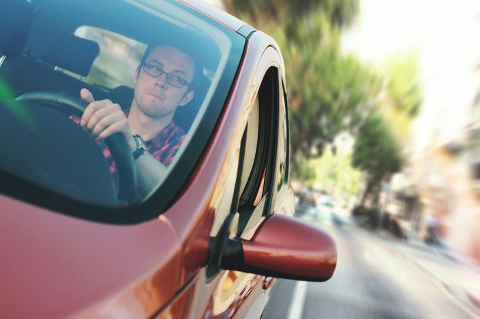 The new driver is looking in the rearview mirror