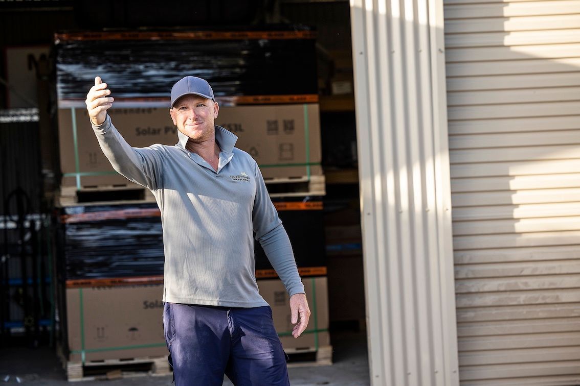 Man Signalling Truck With Packages Of Solar Panels In the Background — Solar Power Whitsunday In Cannon Valley, QLD