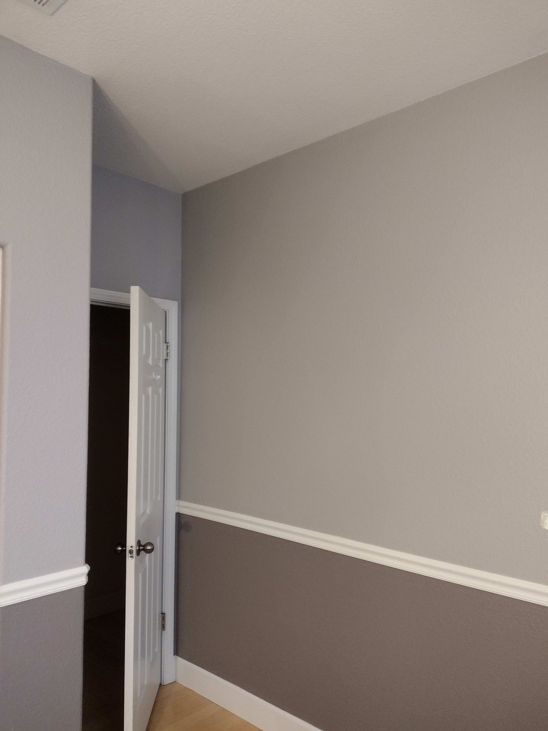 Empty room with gray walls, white trim, and an open white door.
