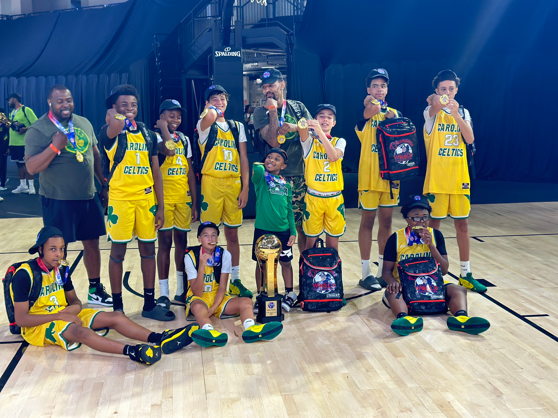A group of young boys are posing for a picture on a basketball court.