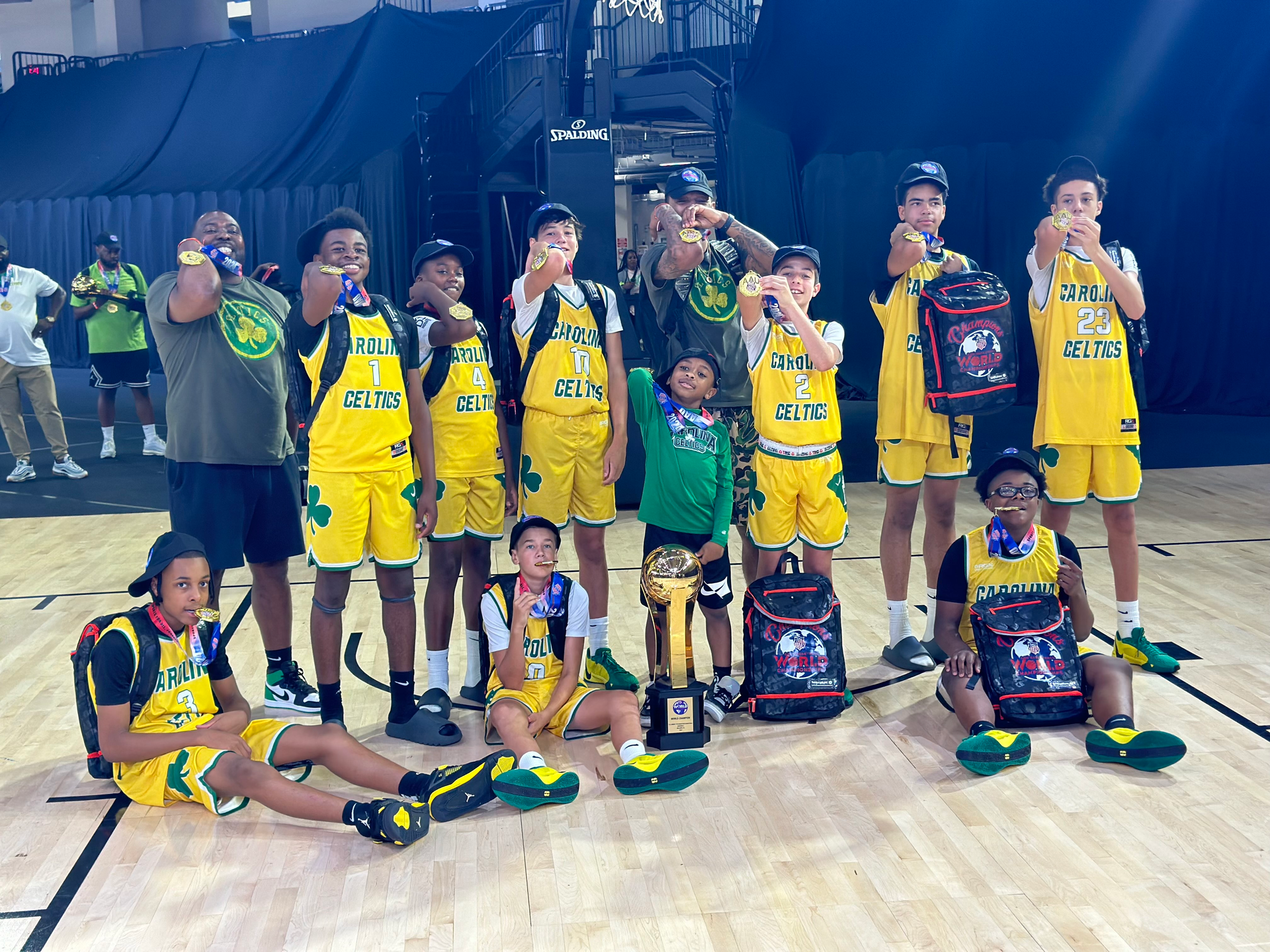 A group of young boys are posing for a picture on a basketball court.