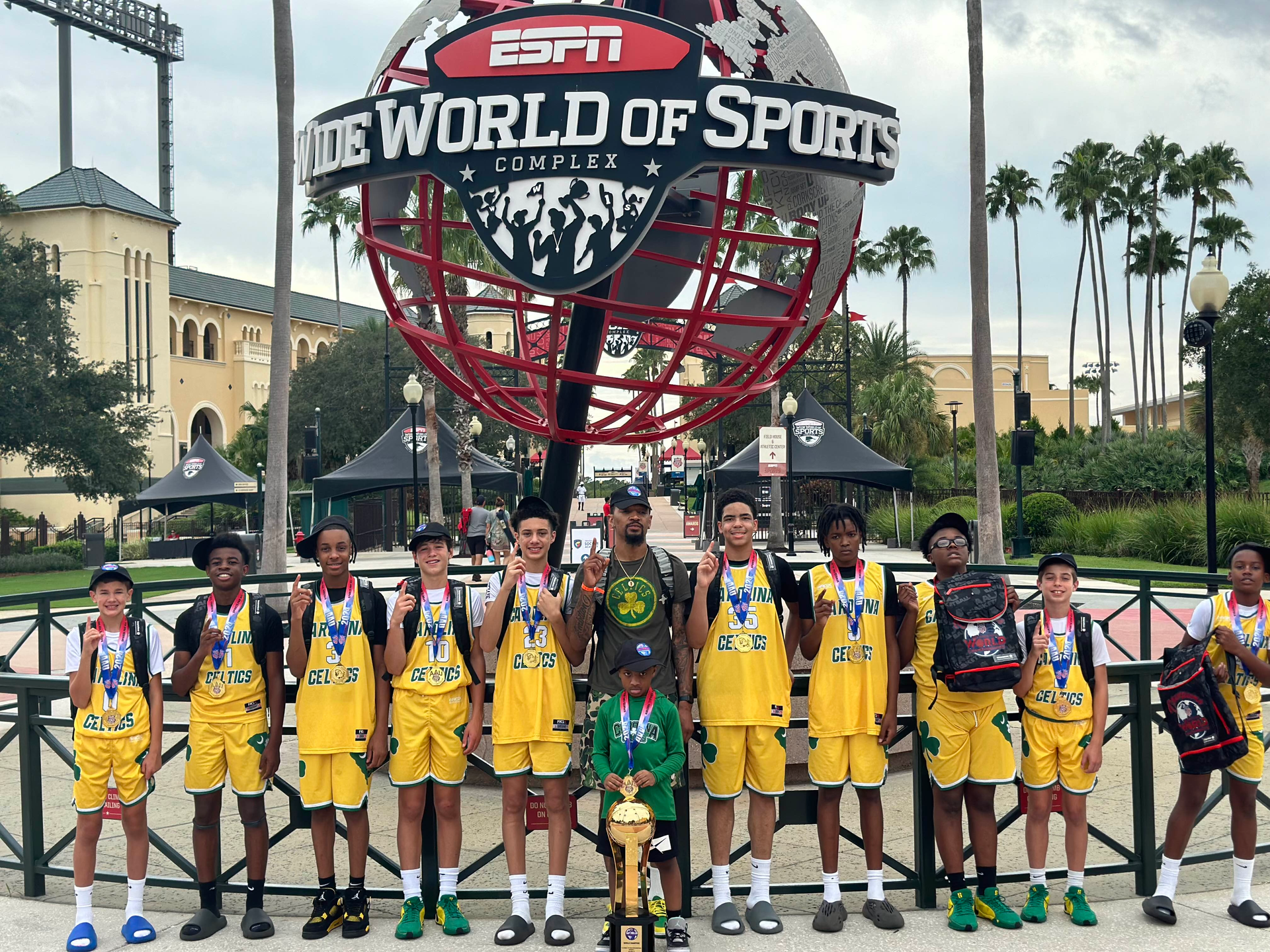 A group of young boys are standing in front of a world of sports sign.