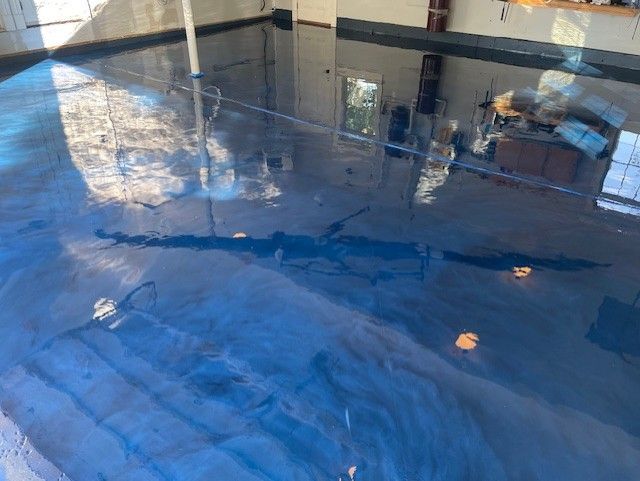 Blue metallic epoxy floor installation in residential space Erie PA by 814 Epoxy