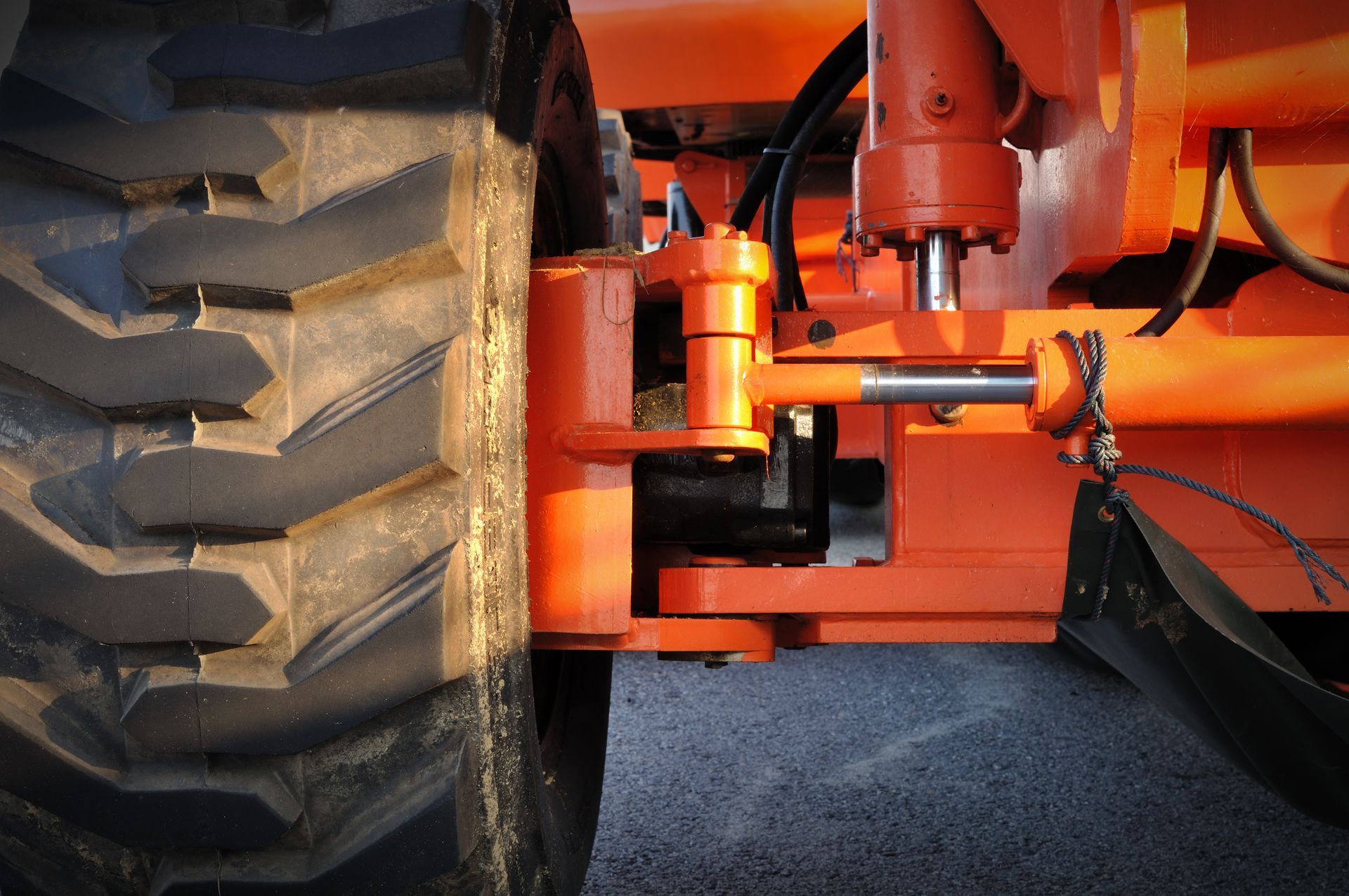 A close up of an orange tractor with a black tire
