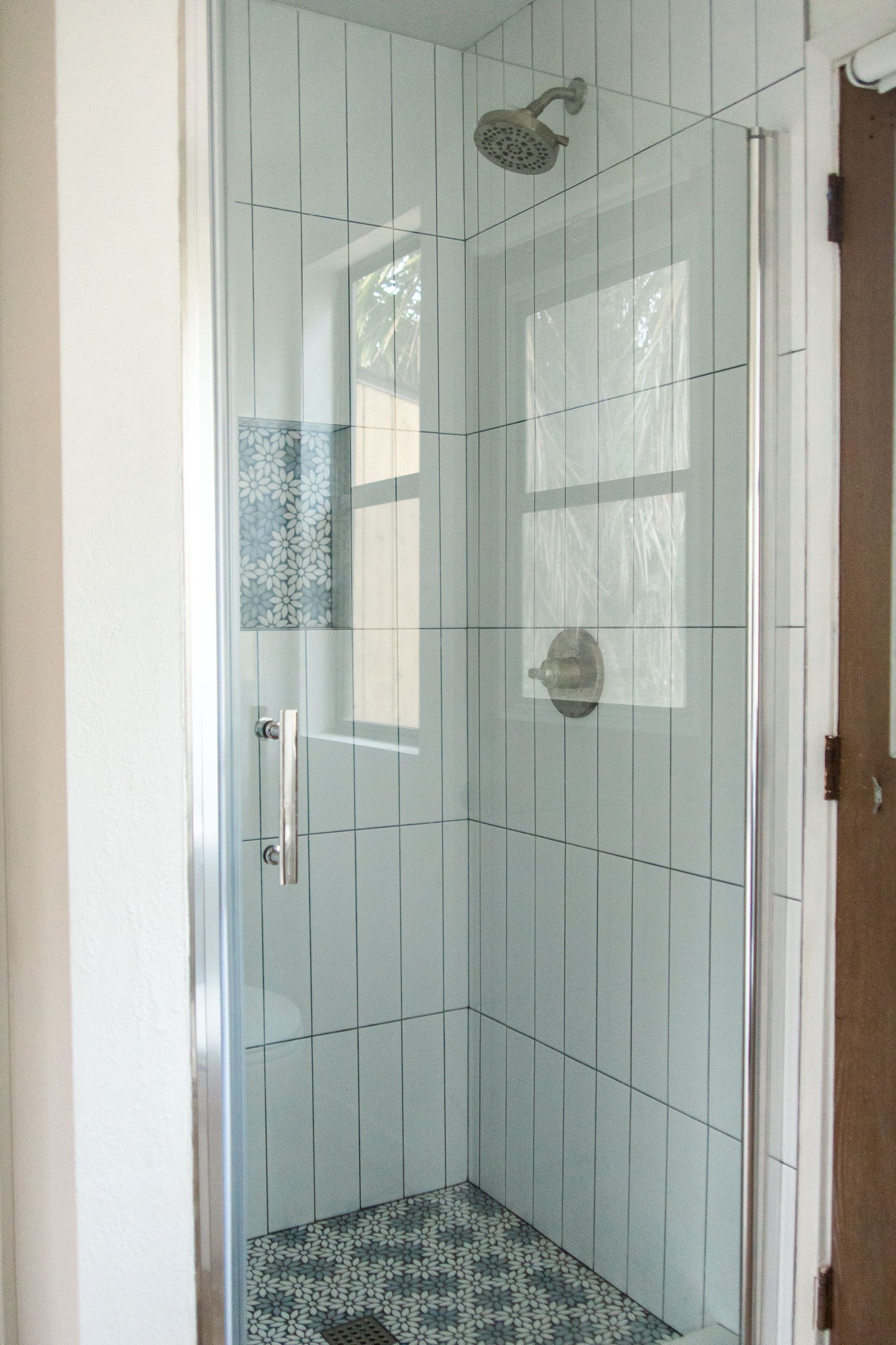 A shelf in a shower wall with a black frame.
