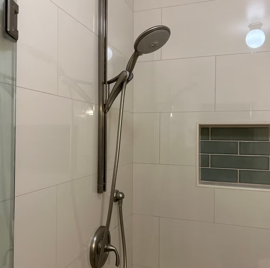 A shower head is hanging from the wall in a bathroom.